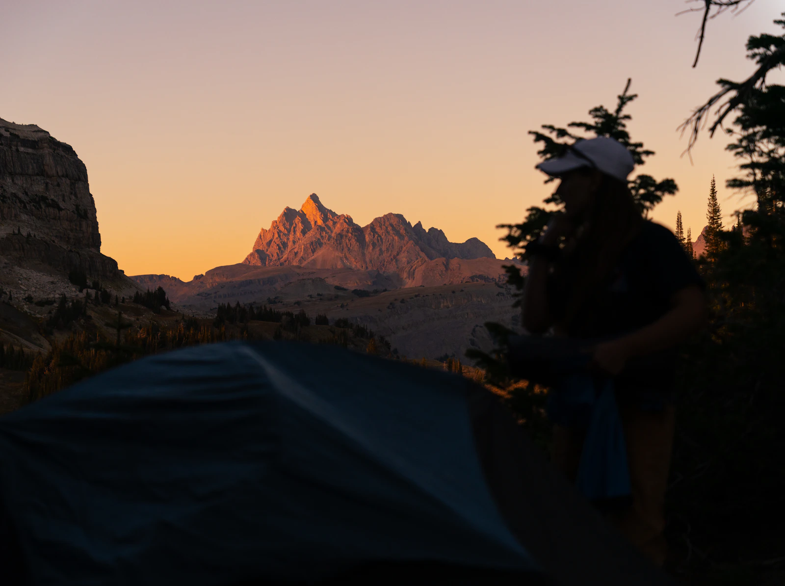 Real campsite tent at sunrise with a mountain backdrop