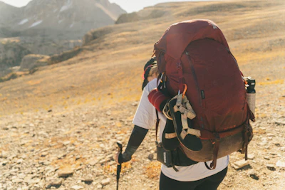 Hiker with large backpack on a rocky mountain trail