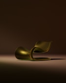 A sleek, golden chaise lounge on a dark background