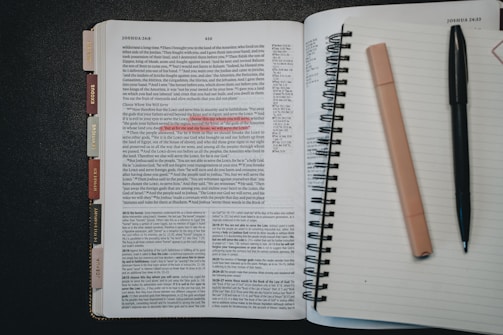 Open book with pen and highlighter on notebook page.
