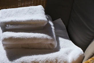 Stack of clean white towels on a surface.