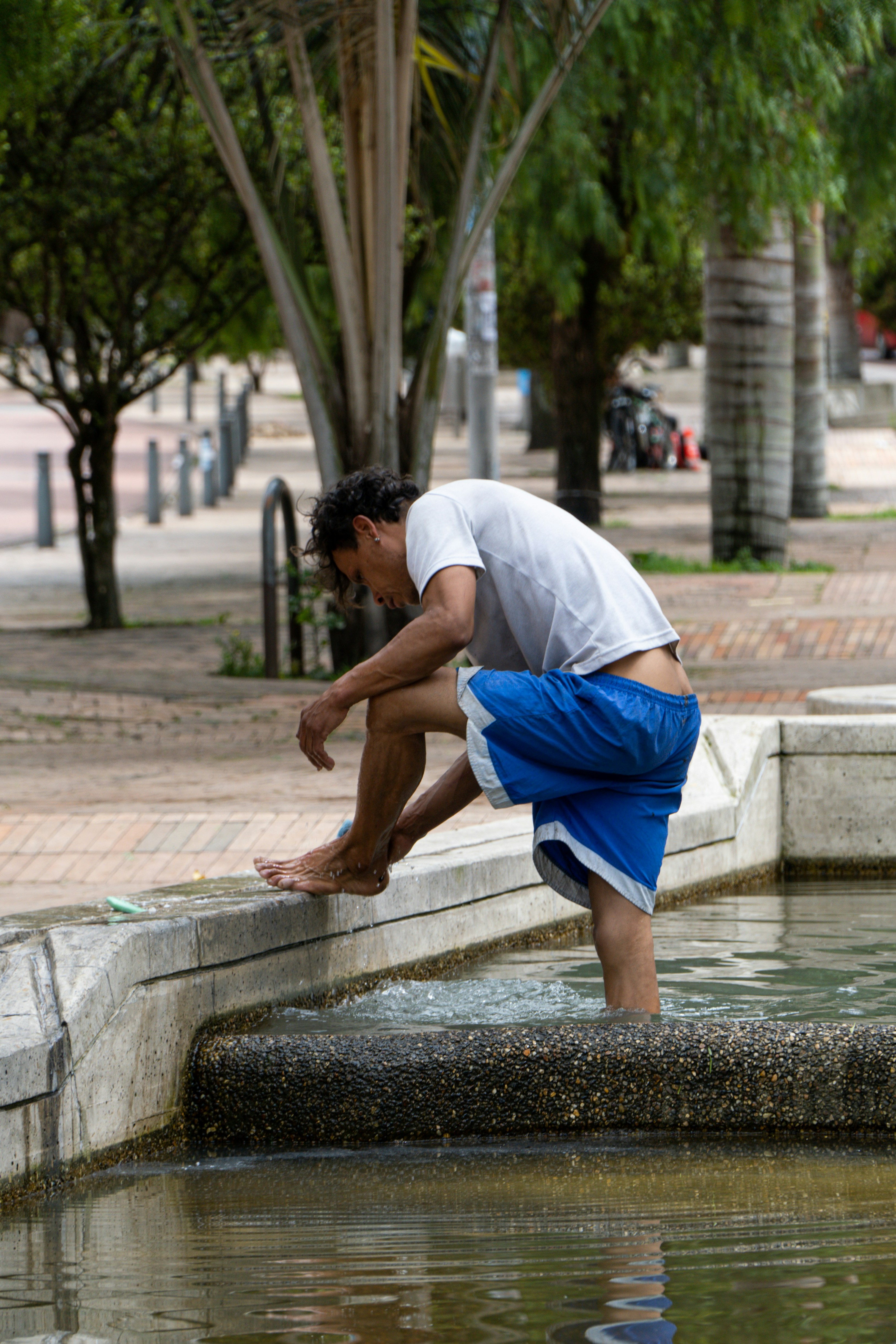 Man cooling feet in fountain on a hot day