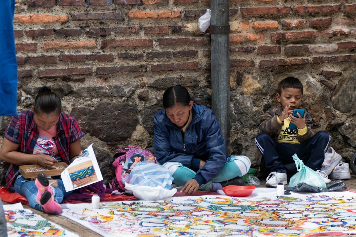 Three people sitting on the ground organizing items for a nonprofit capital campaign fundraiser.