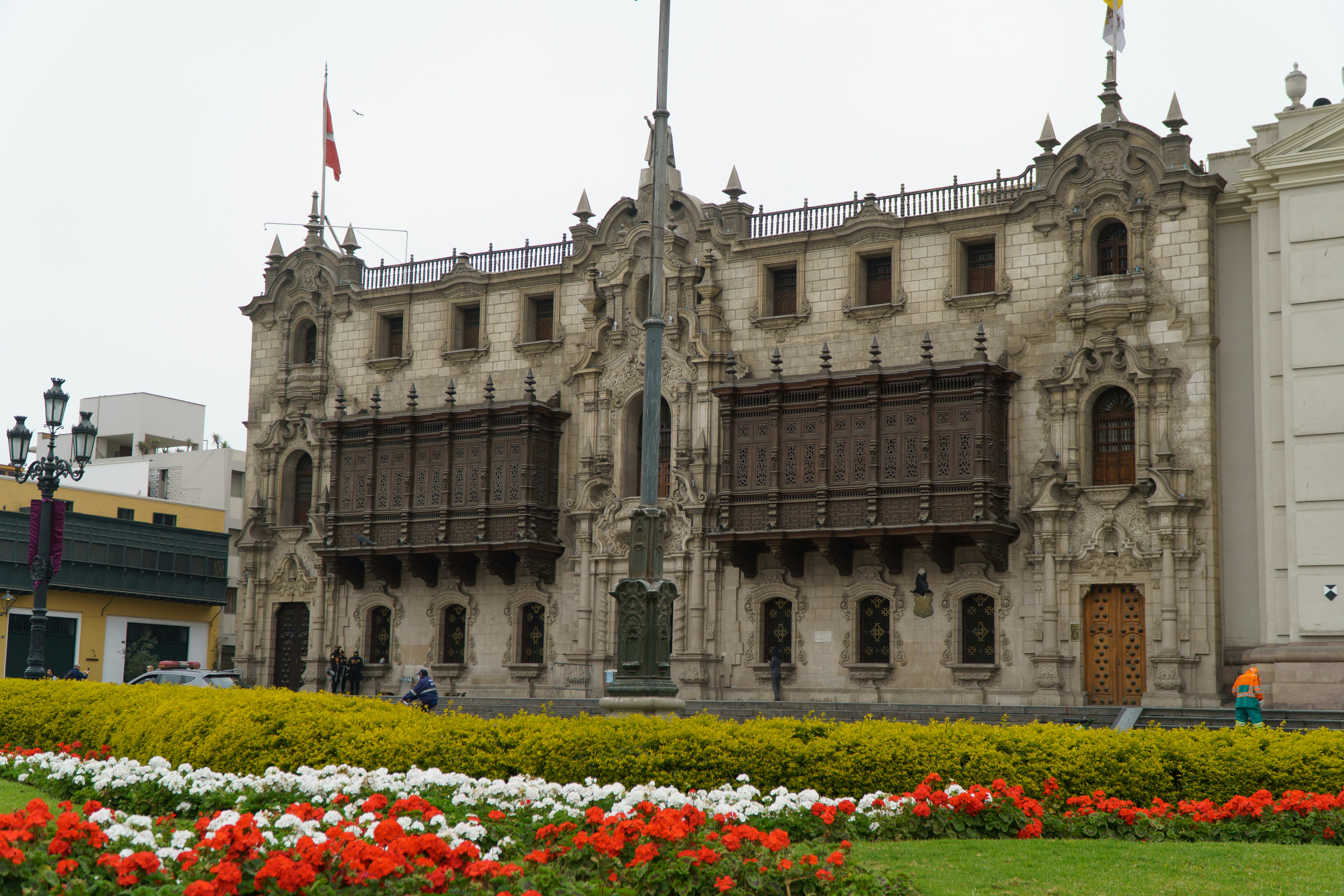 Edificio ornamentado con banderas y jardín de flores
