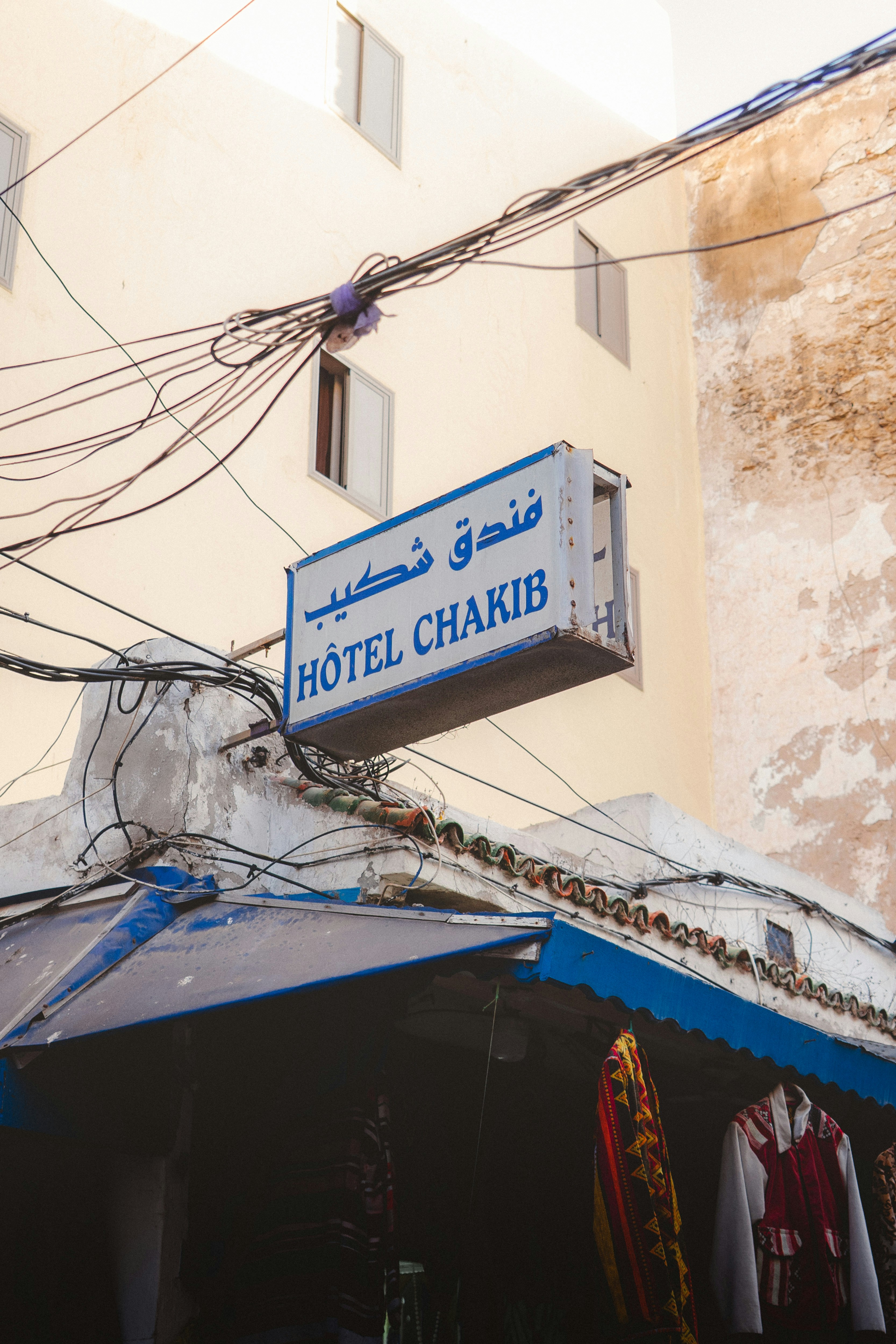 Hotel chakib sign above a shop entrance with wires