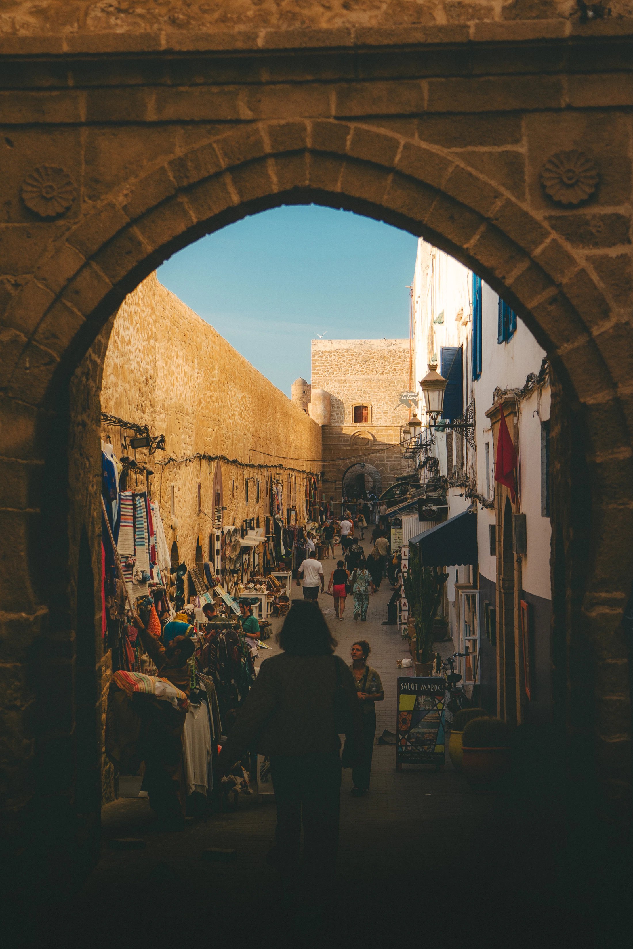 Stone arch opening onto a market street in Essaouira medina