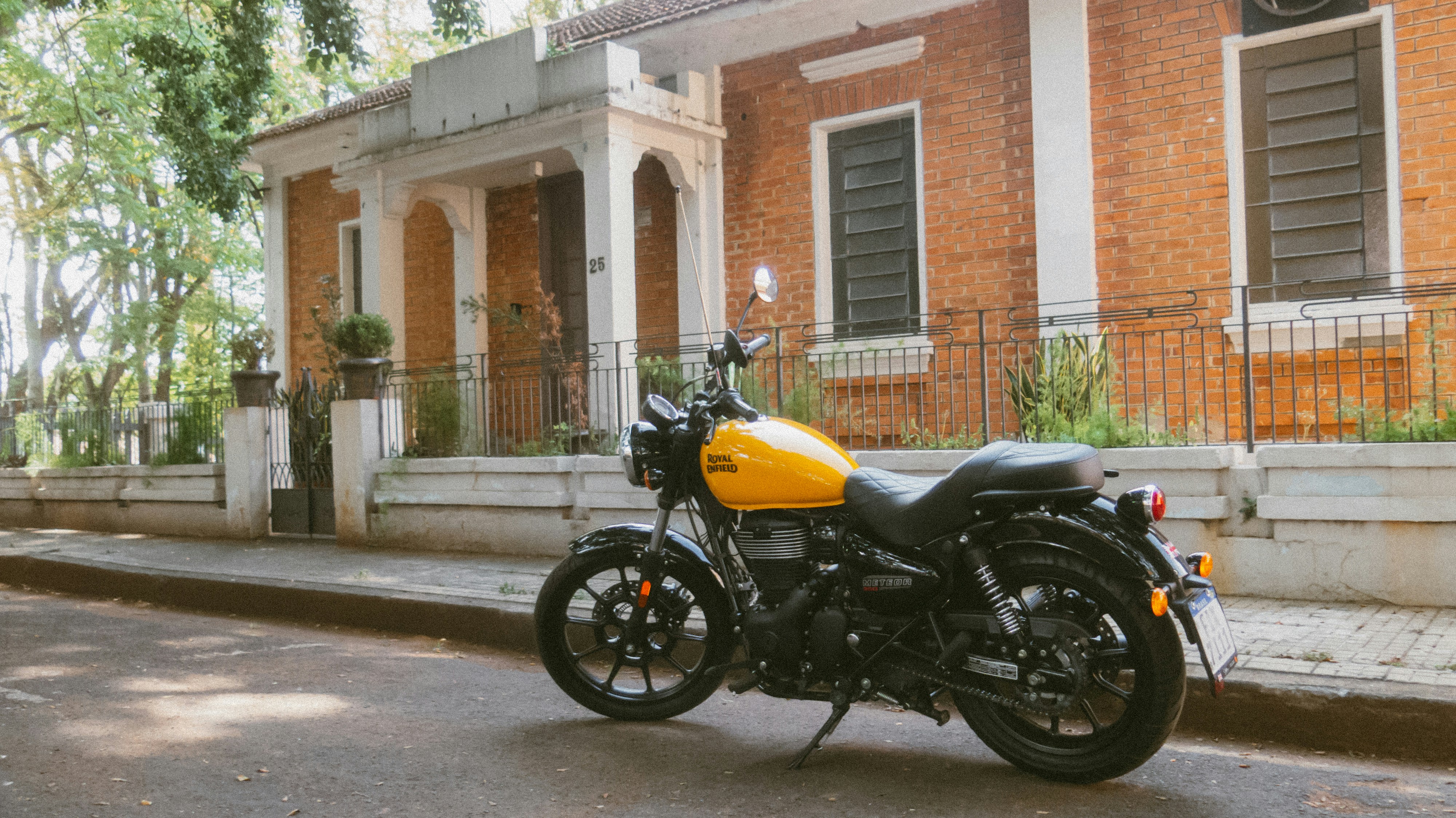 Yellow motorcycle parked on a street near building
