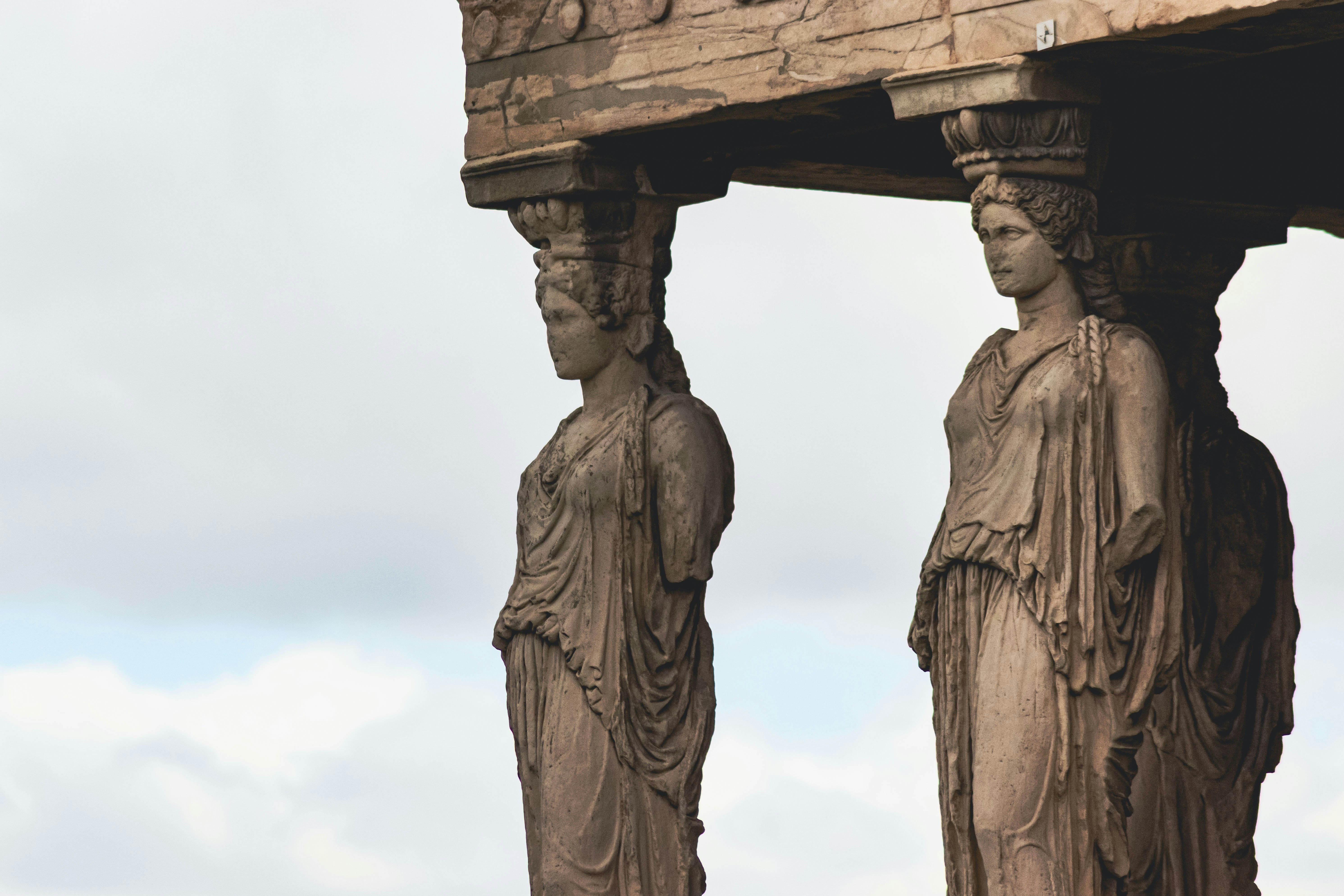 Zwei antike griechische Statuen, die ein Gebäude stützen