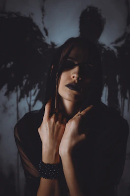 Woman with dark makeup and shadow wings behind her.