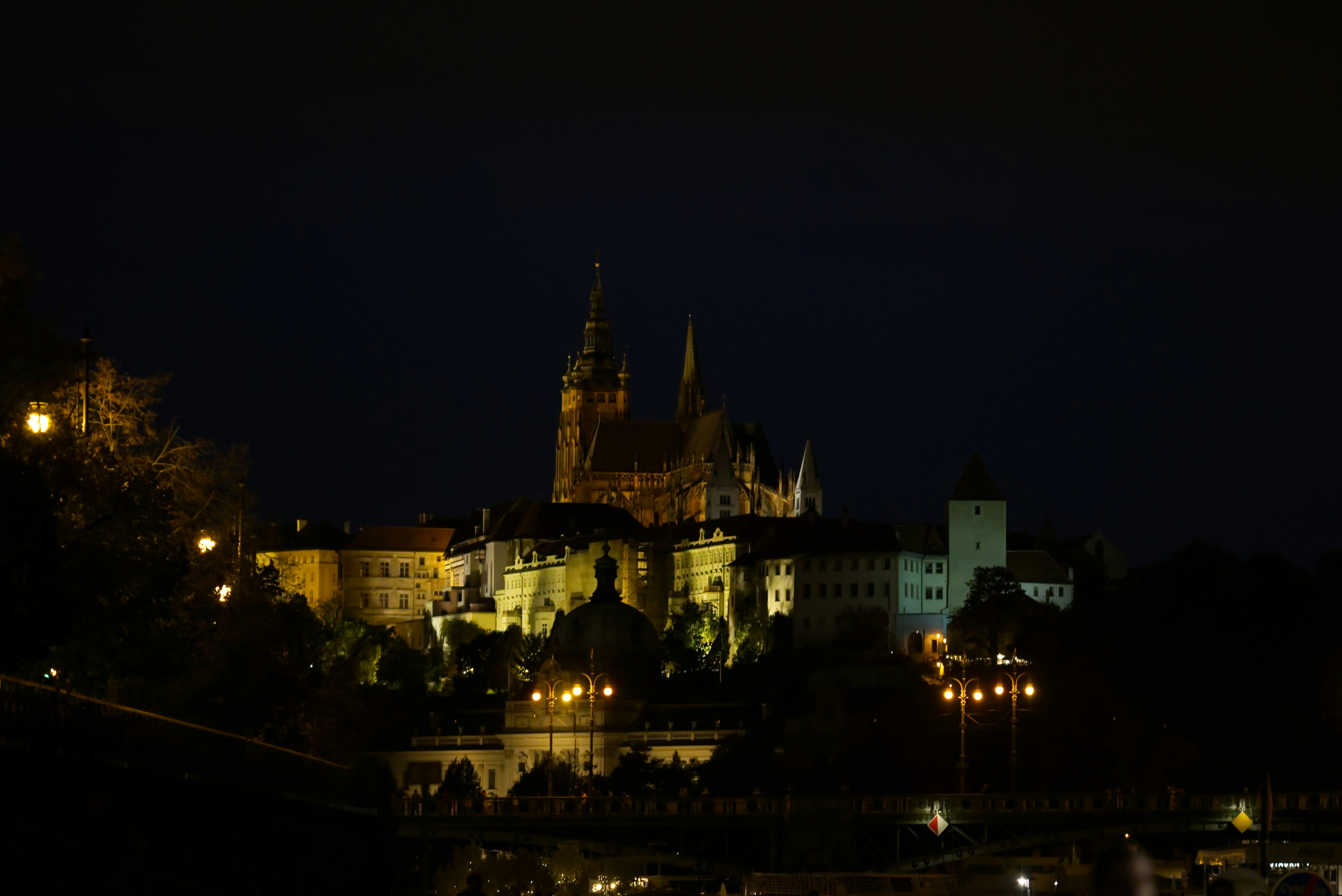 Illuminated castle complex at night under dark sky