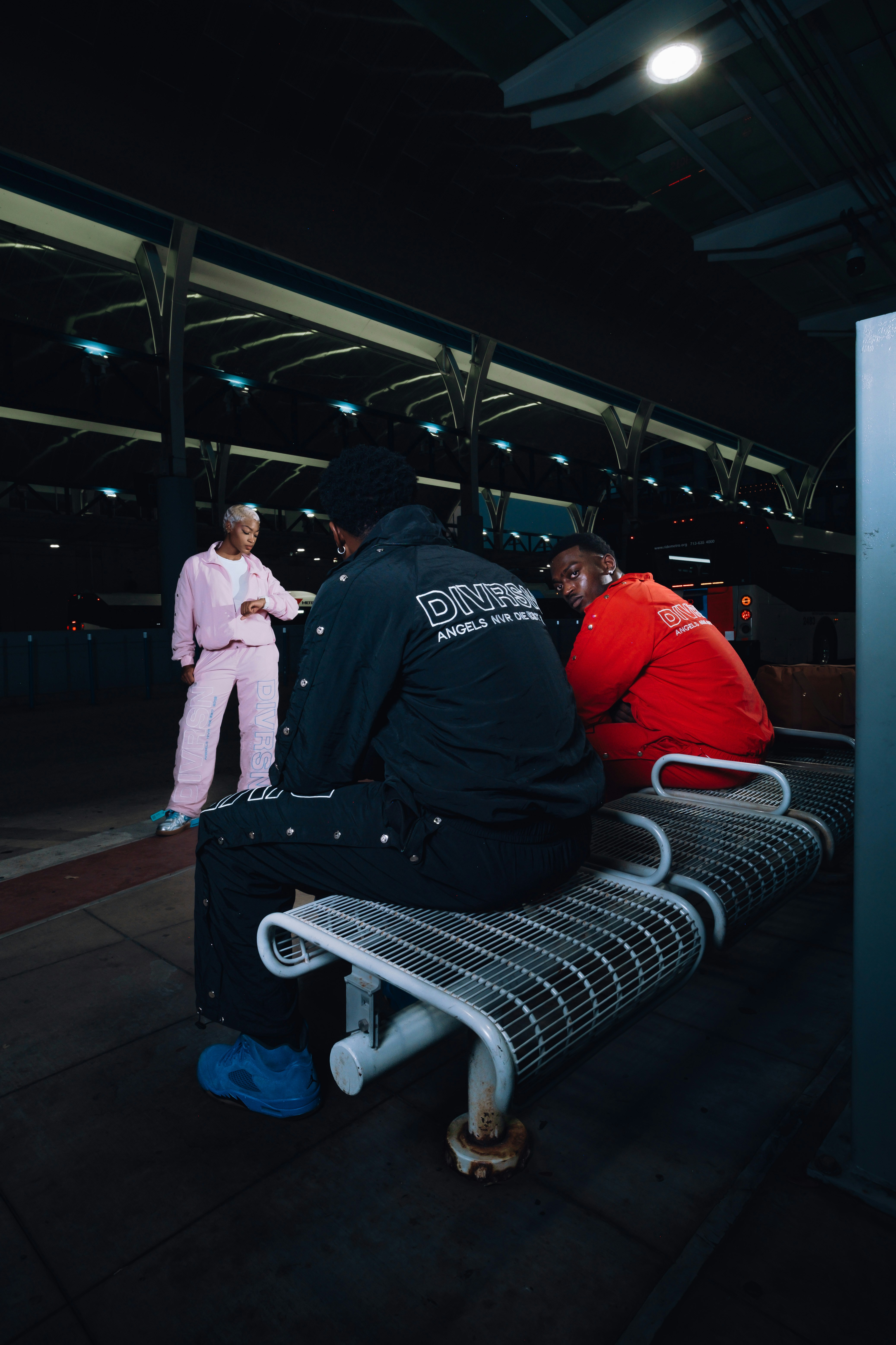 Three people sitting and standing on a bench