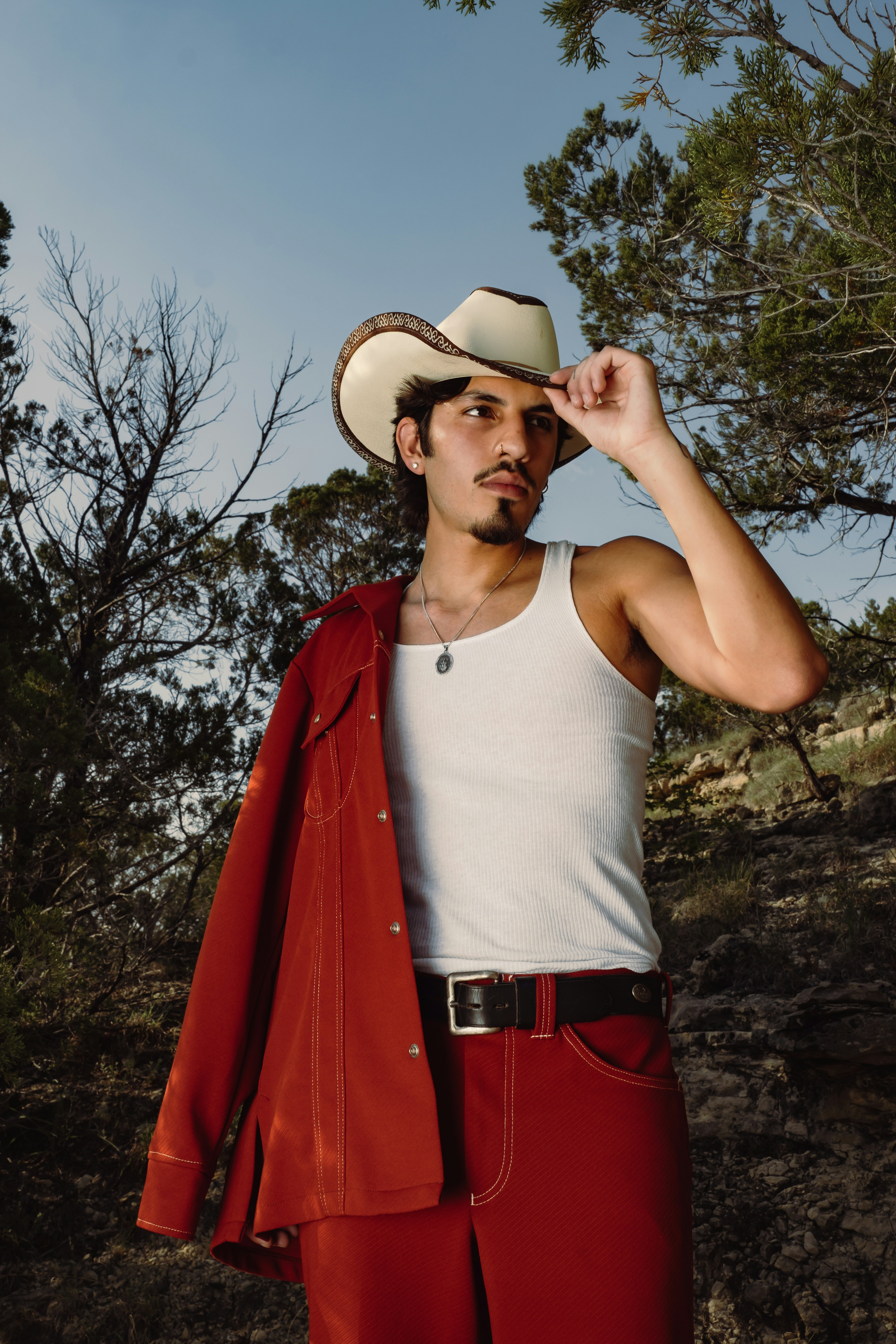 Mann mit Cowboyhut und rotem Anzug in der Natur