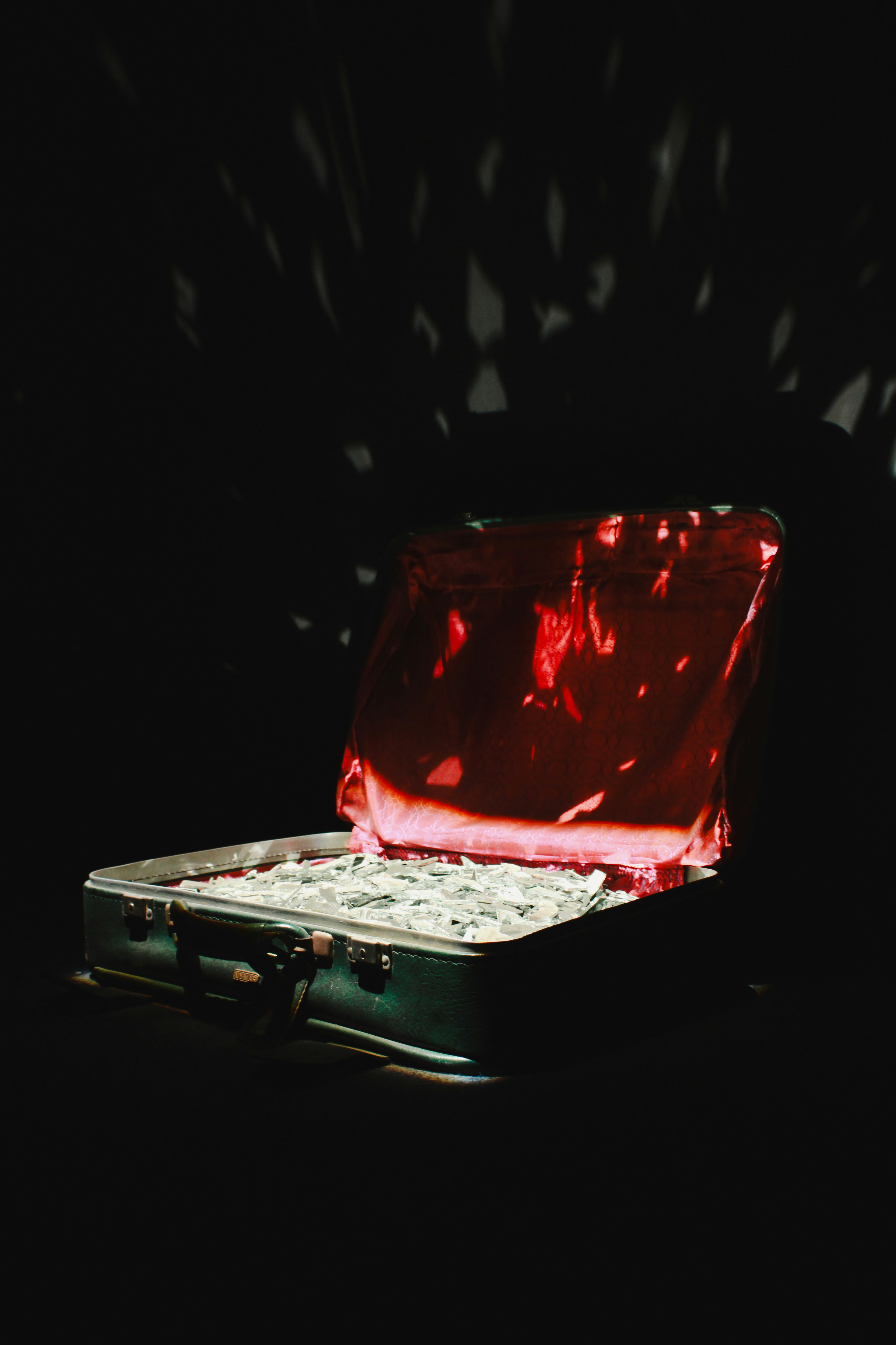 Koffer gefüllt mit Geld und rotem Stoff.