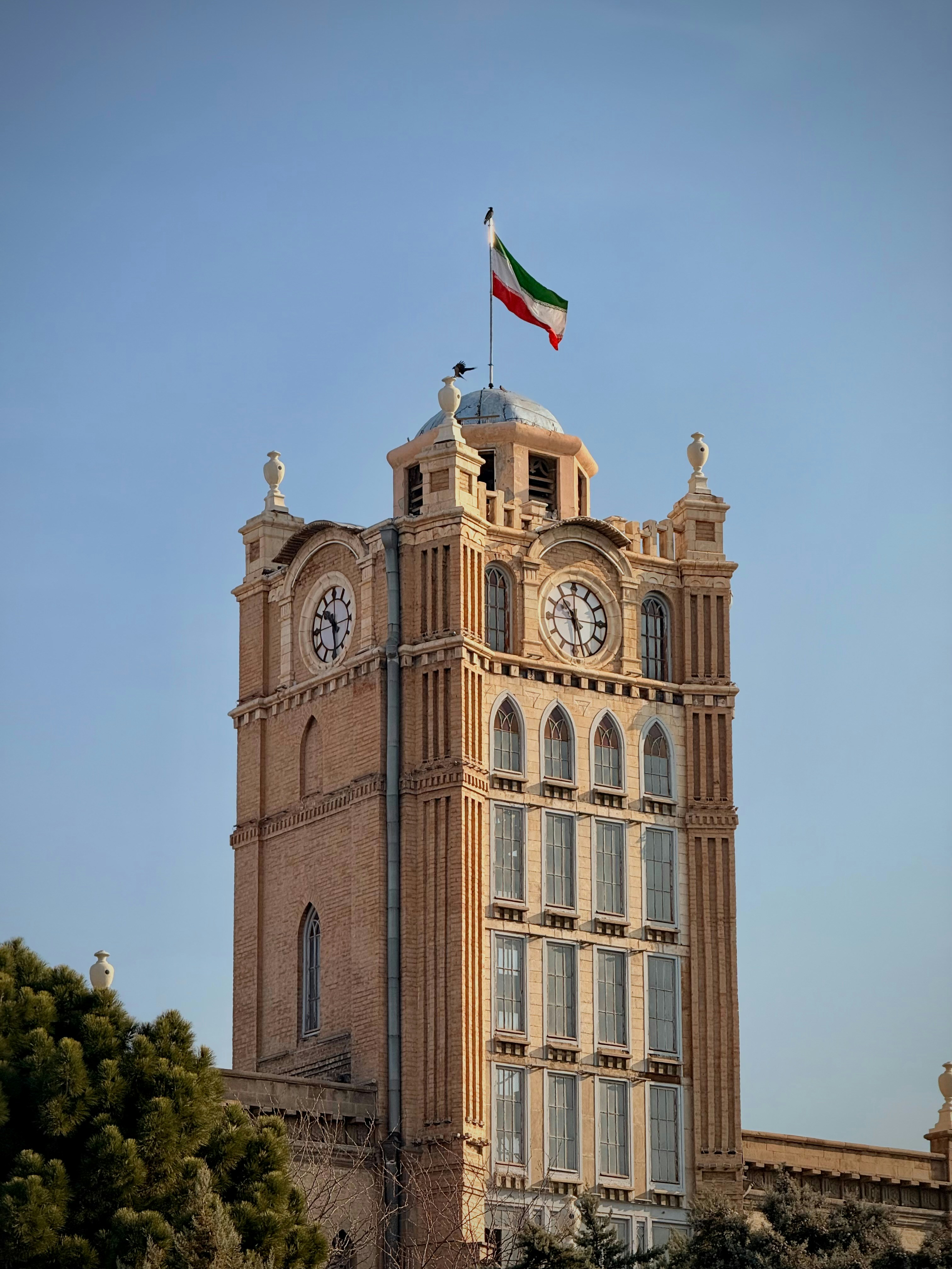 Historischer Turm mit Flagge vor strahlend blauem Himmel