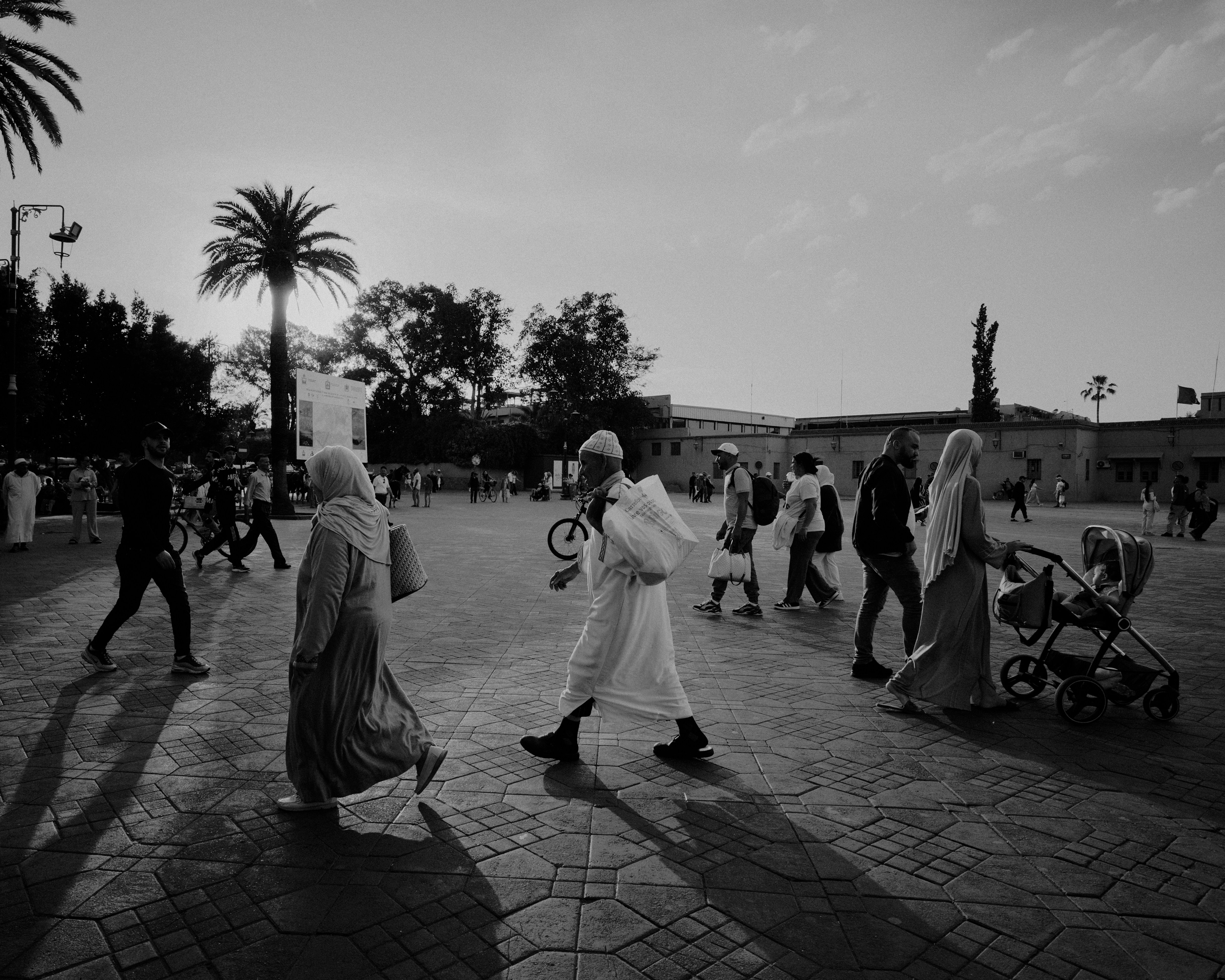 People walking in a square at sunset