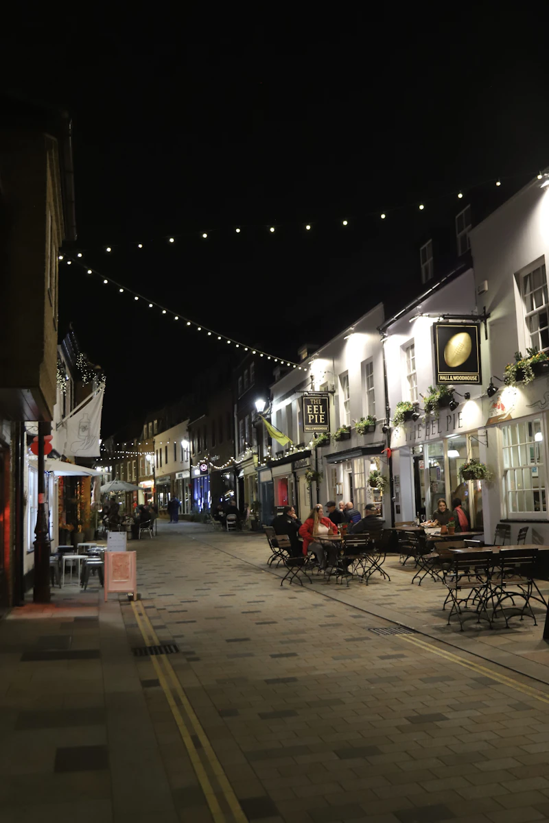 A narrow street lined with restaurants and colorful signage, representing the exploration-exploitation trade-off where an algorithm must choose between familiar options and new possibilities