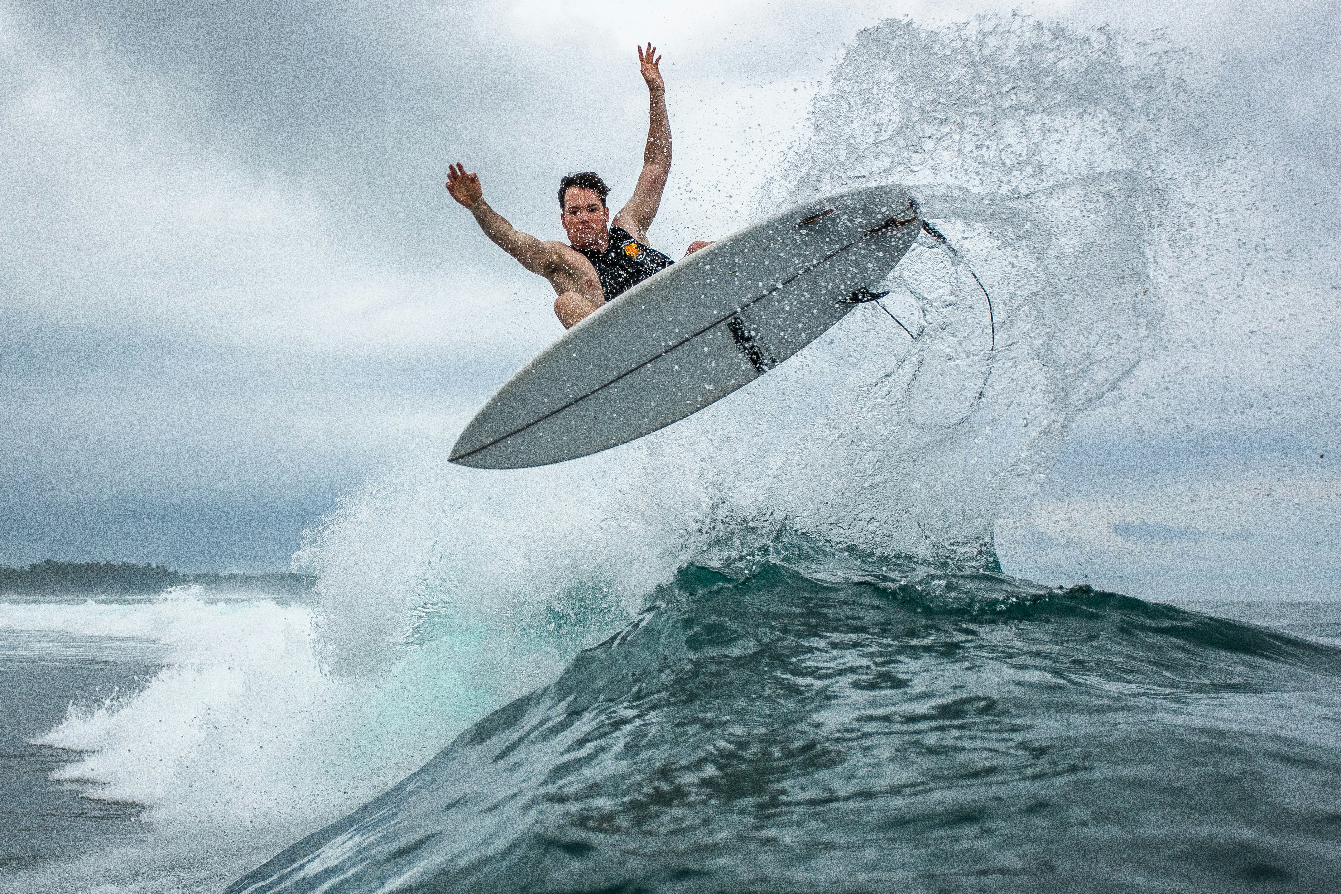 Der Surfer fängt die Luft und führt einen Trick auf der Welle aus.