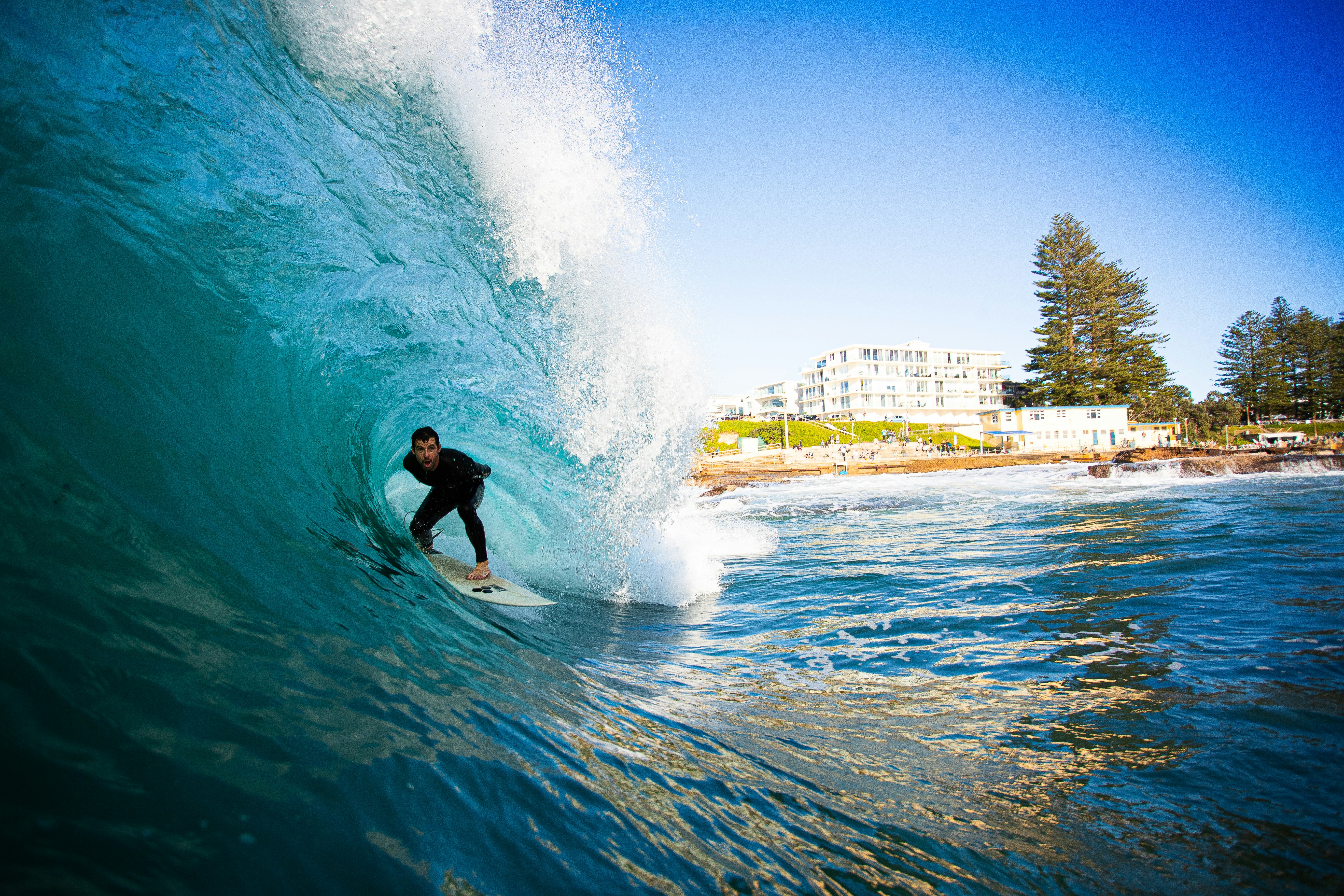 Surfer rides a large turquoise wave