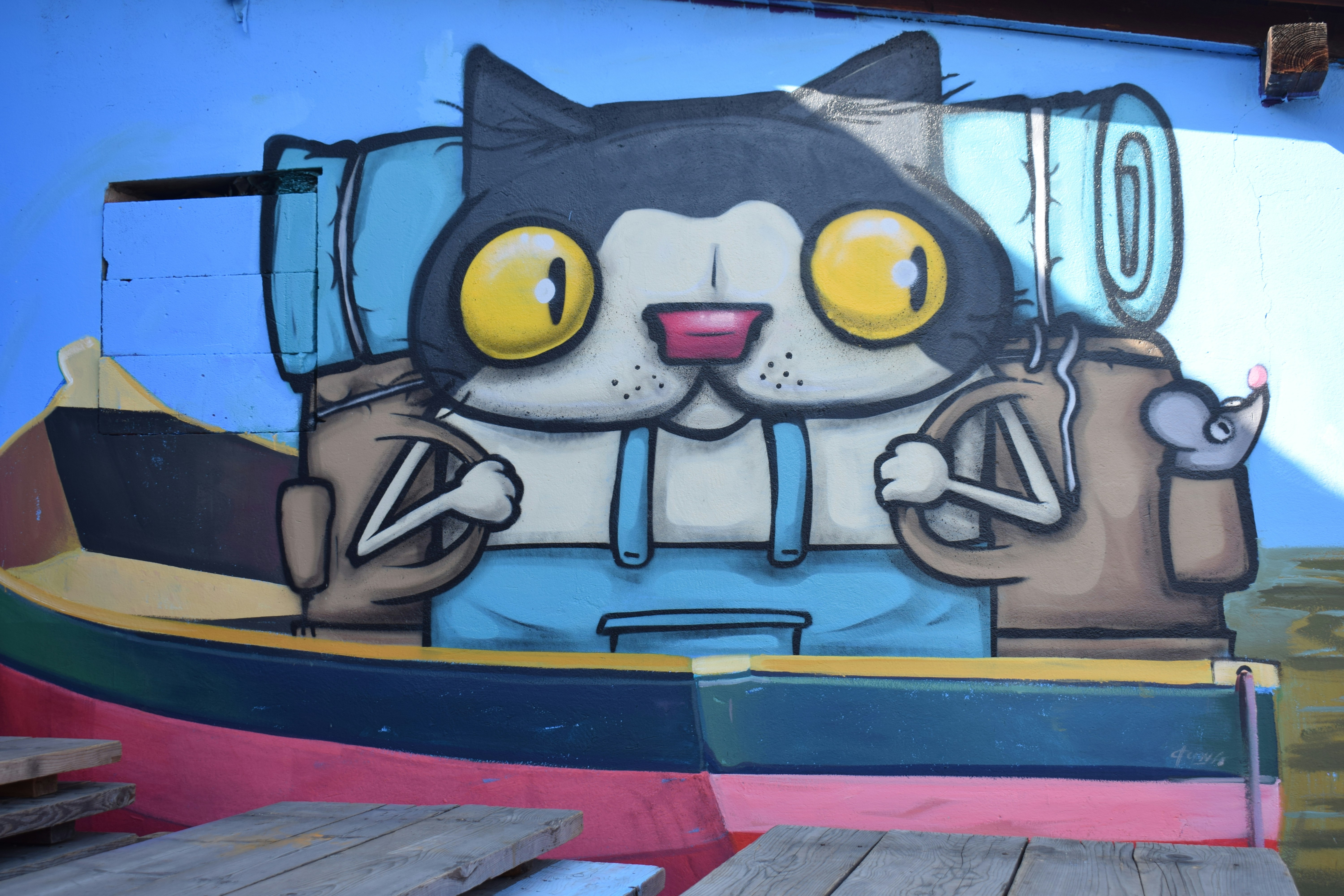 Cartoon cat in a boat with backpacks