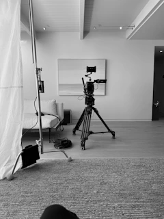 Camera on tripod in a minimalist studio setting.