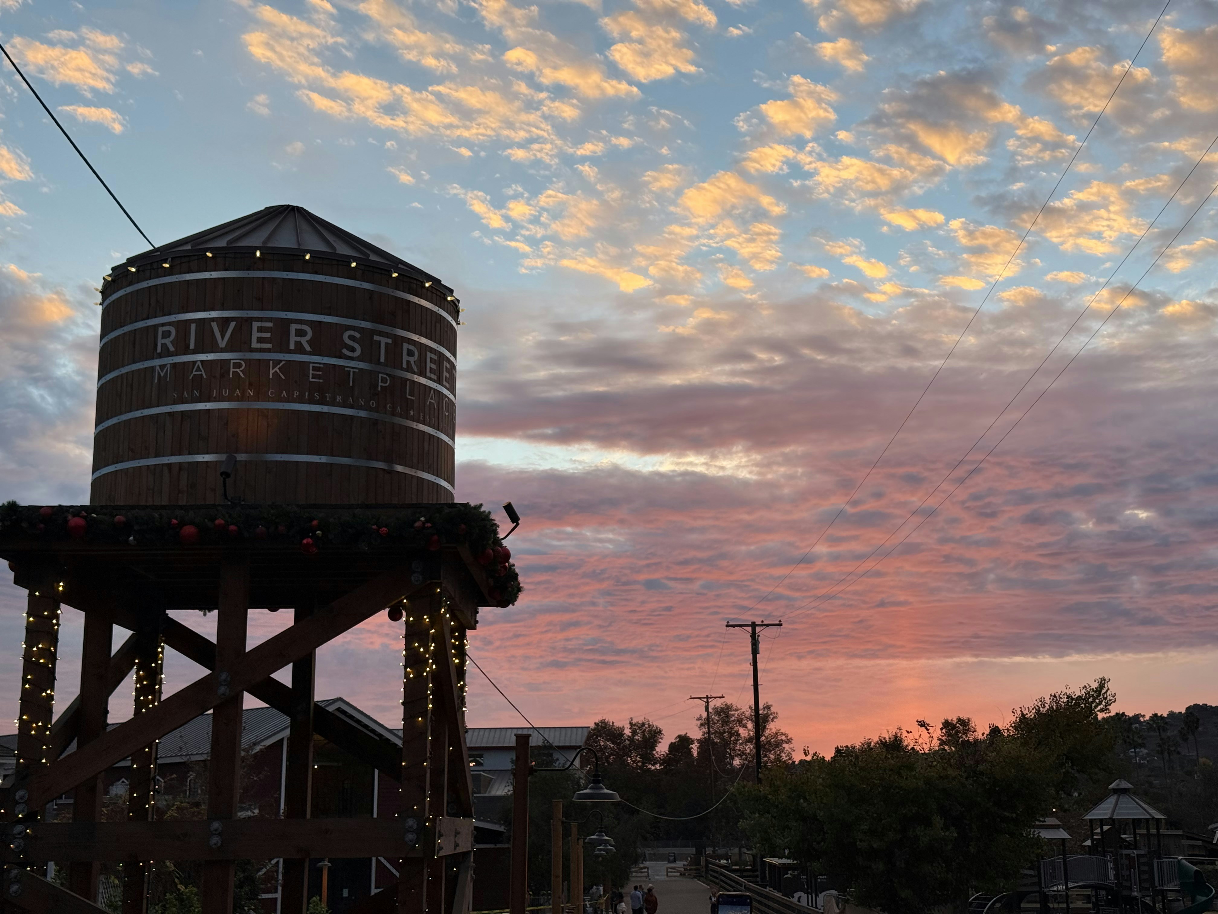 Rustic water tower against a colorful sunset sky