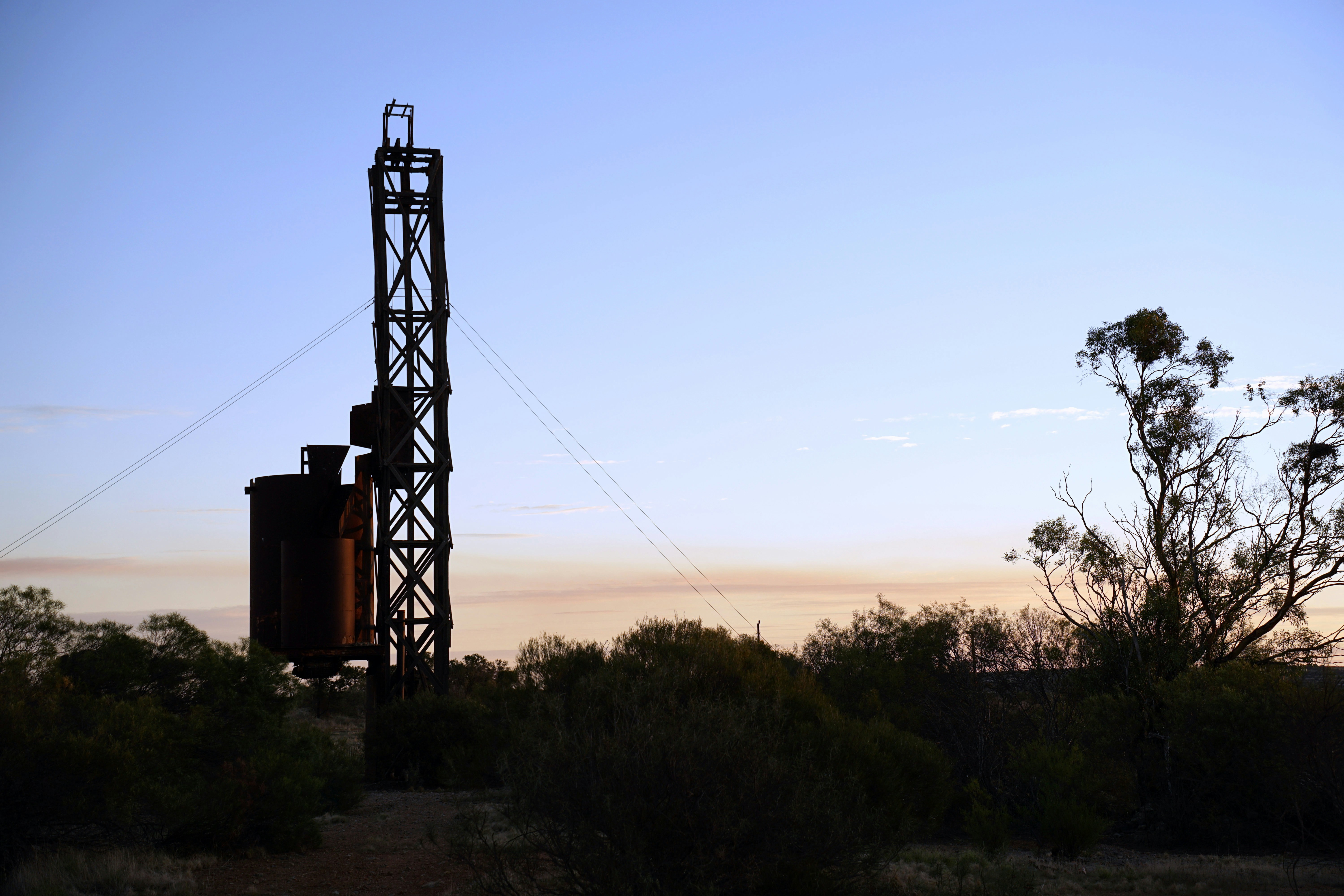 Silhouette of an old mine shaft at sunset.