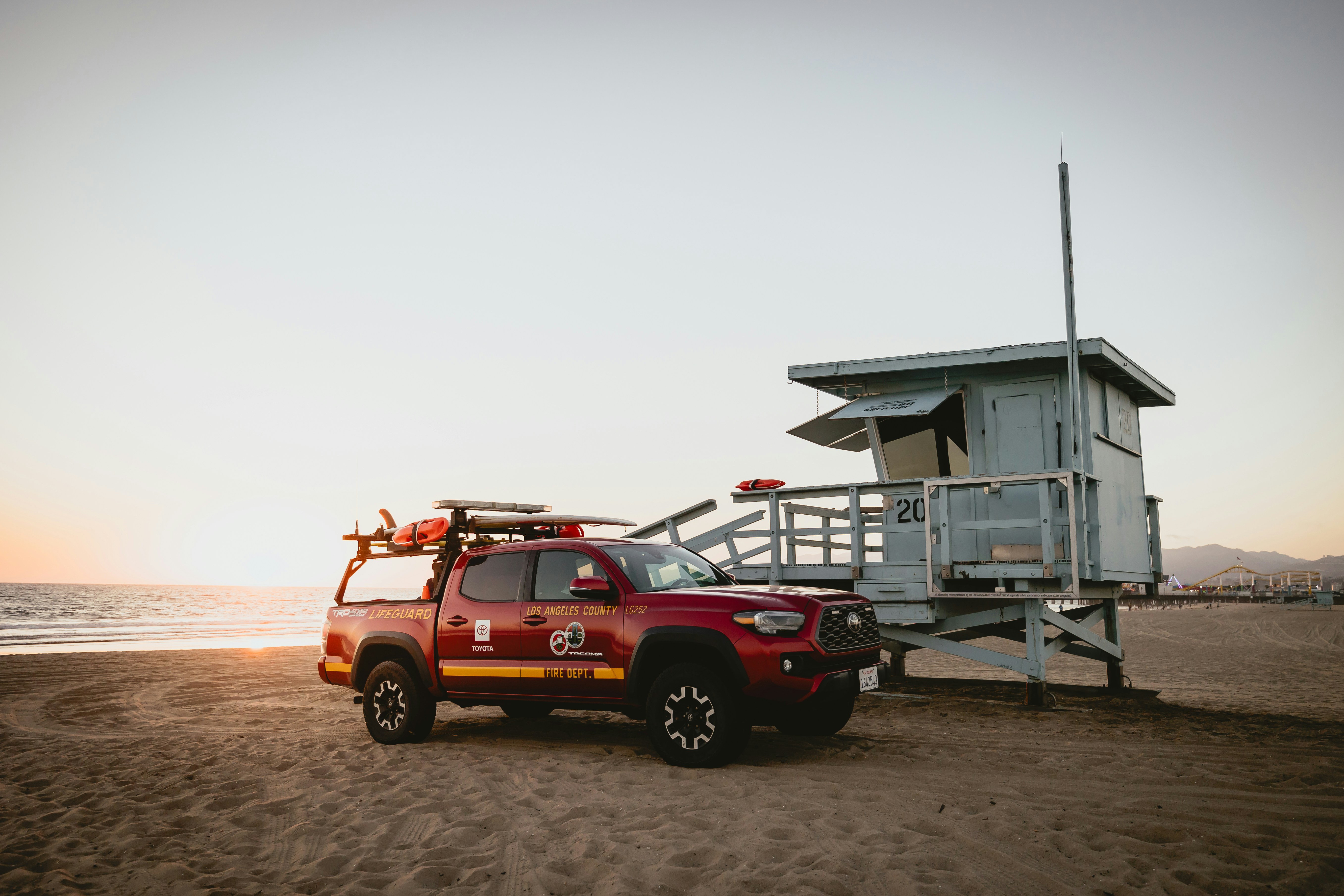 Rettungsschwimmer-Truck parkt bei einem Turm am Strand