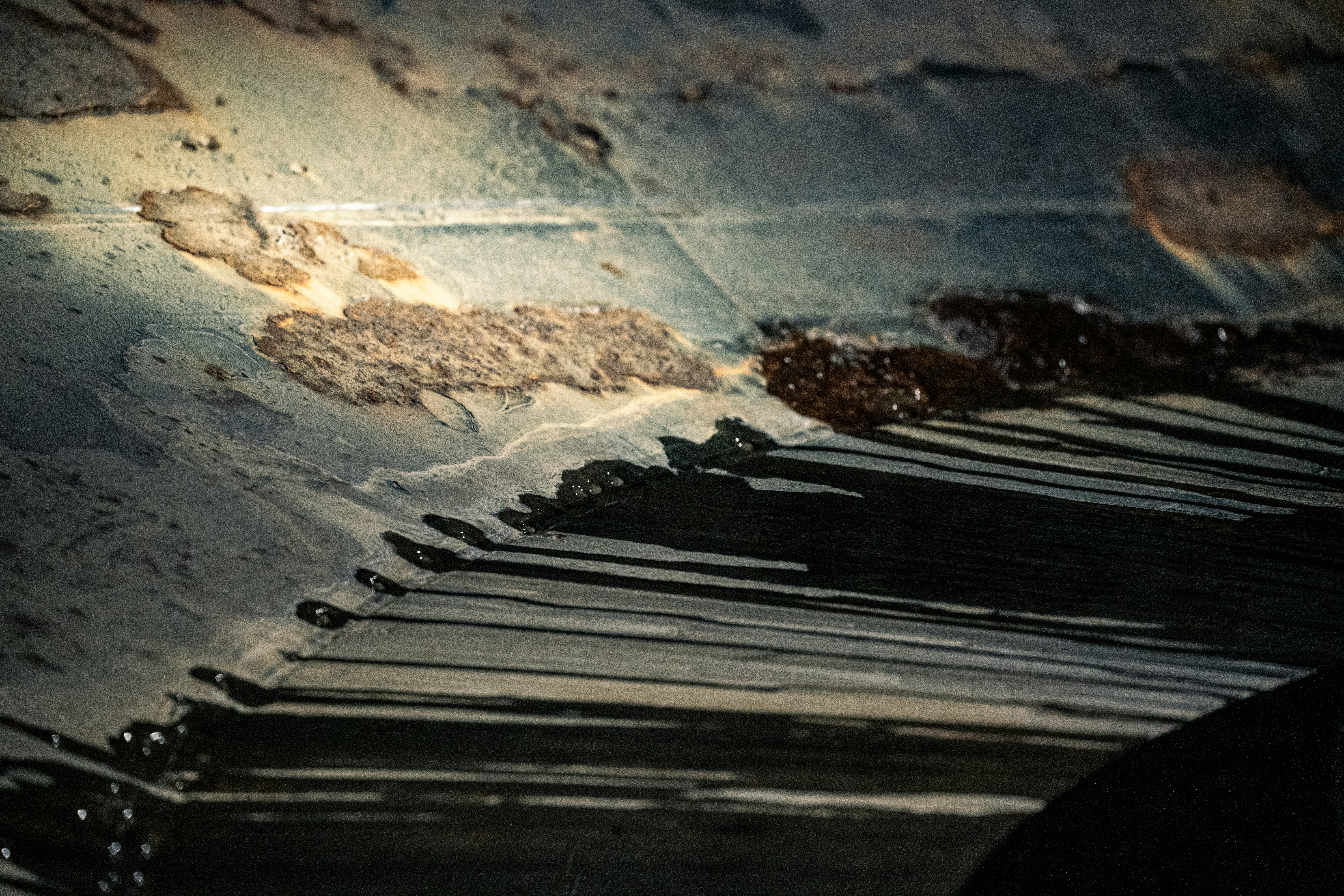 Close-up of corroded metal surface with rust and peeling paint.
