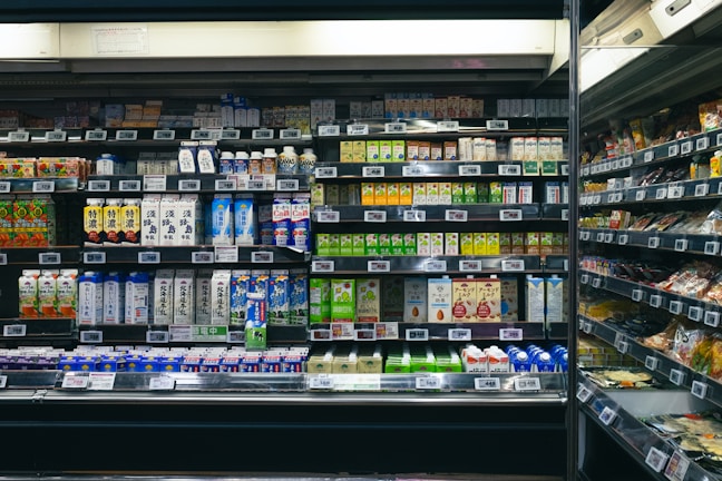 Shelves stocked with beverages and food items in a store.