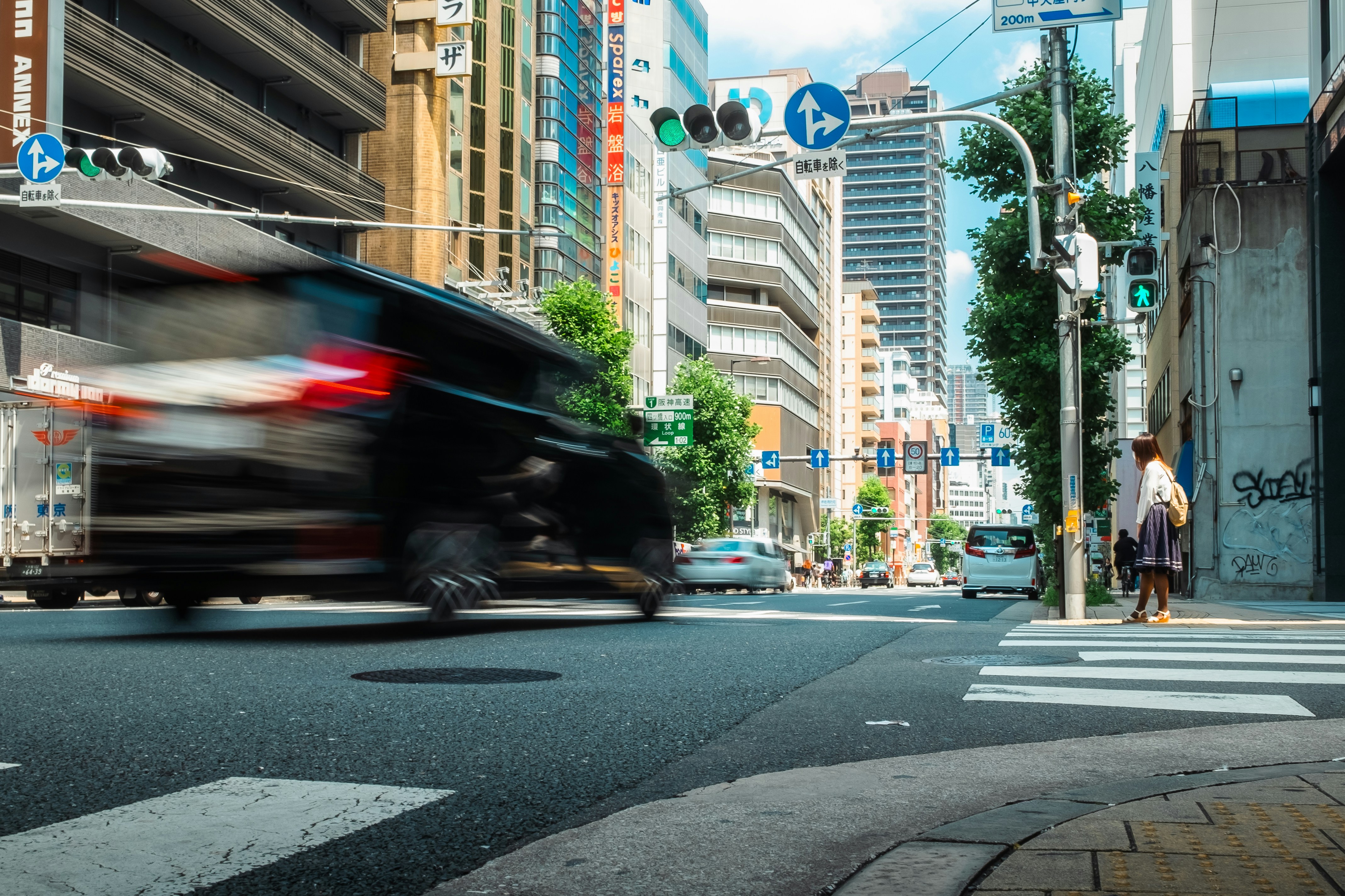 ぼやけた市街地の交差点をスピード違反で走る車
