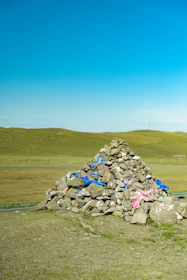 Cairn of rocks with blue and pink ribbons