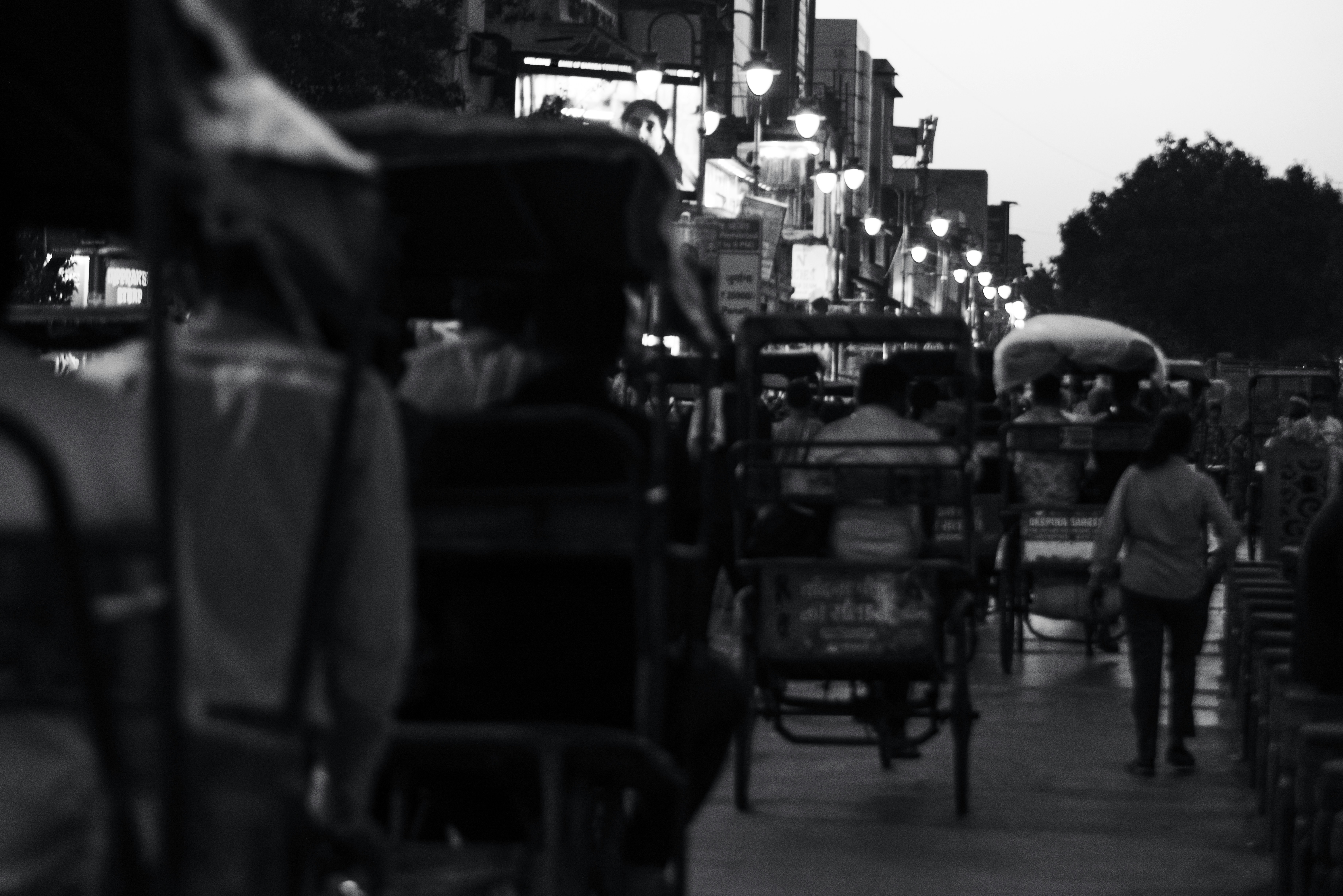 Kalabalık ve hareketli bir şehir caddesinde, etrafındaki insanlar hızla akıp giderken duran, düşünceli ve yalnız hisseden bir kişinin dramatik fotoğrafı.