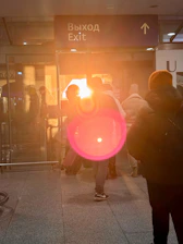 People near an exit sign with lens flare