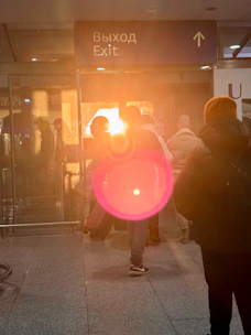 People near an exit sign with lens flare
