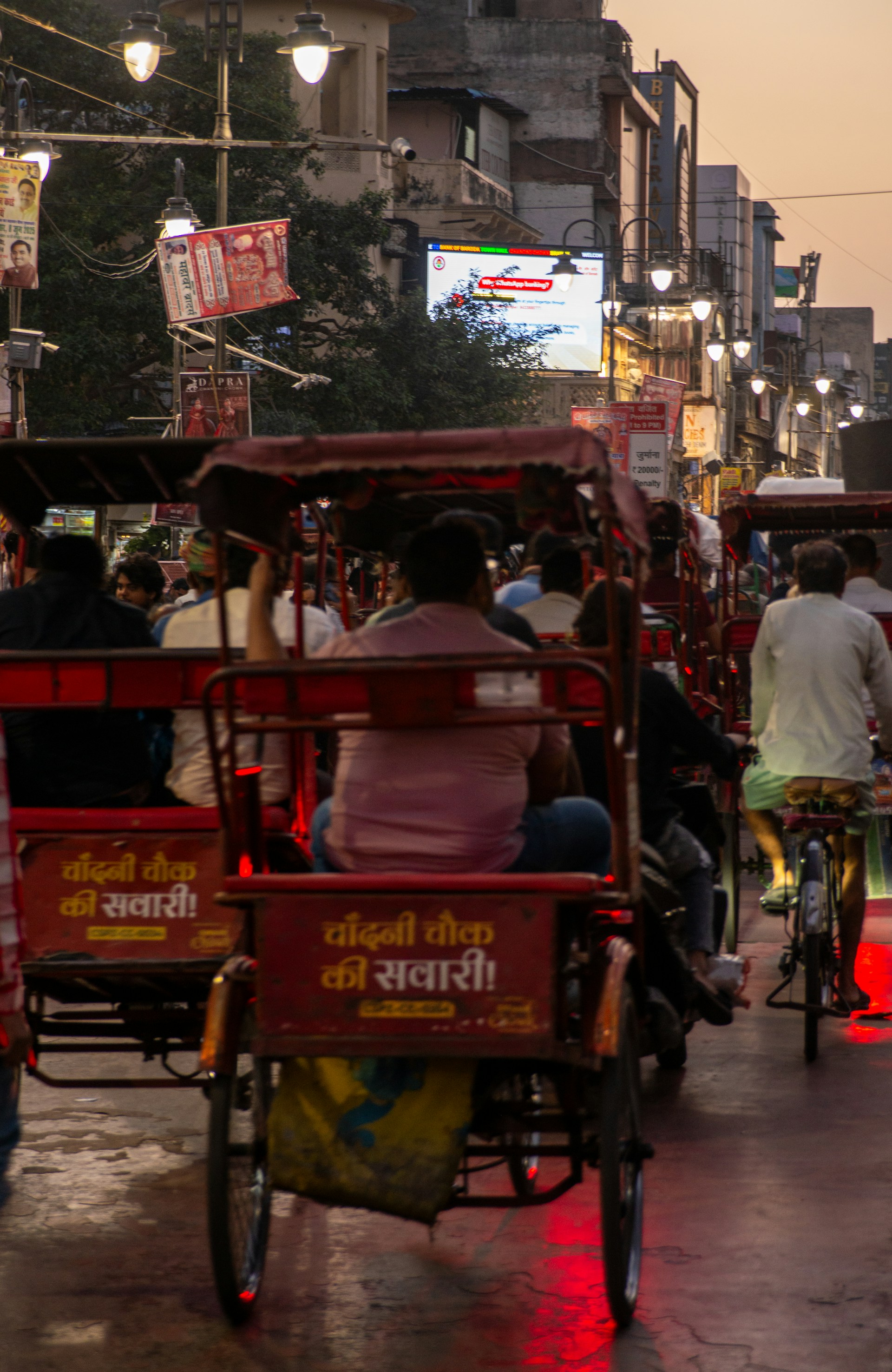 Rickshaws and bicycles on a busy street.