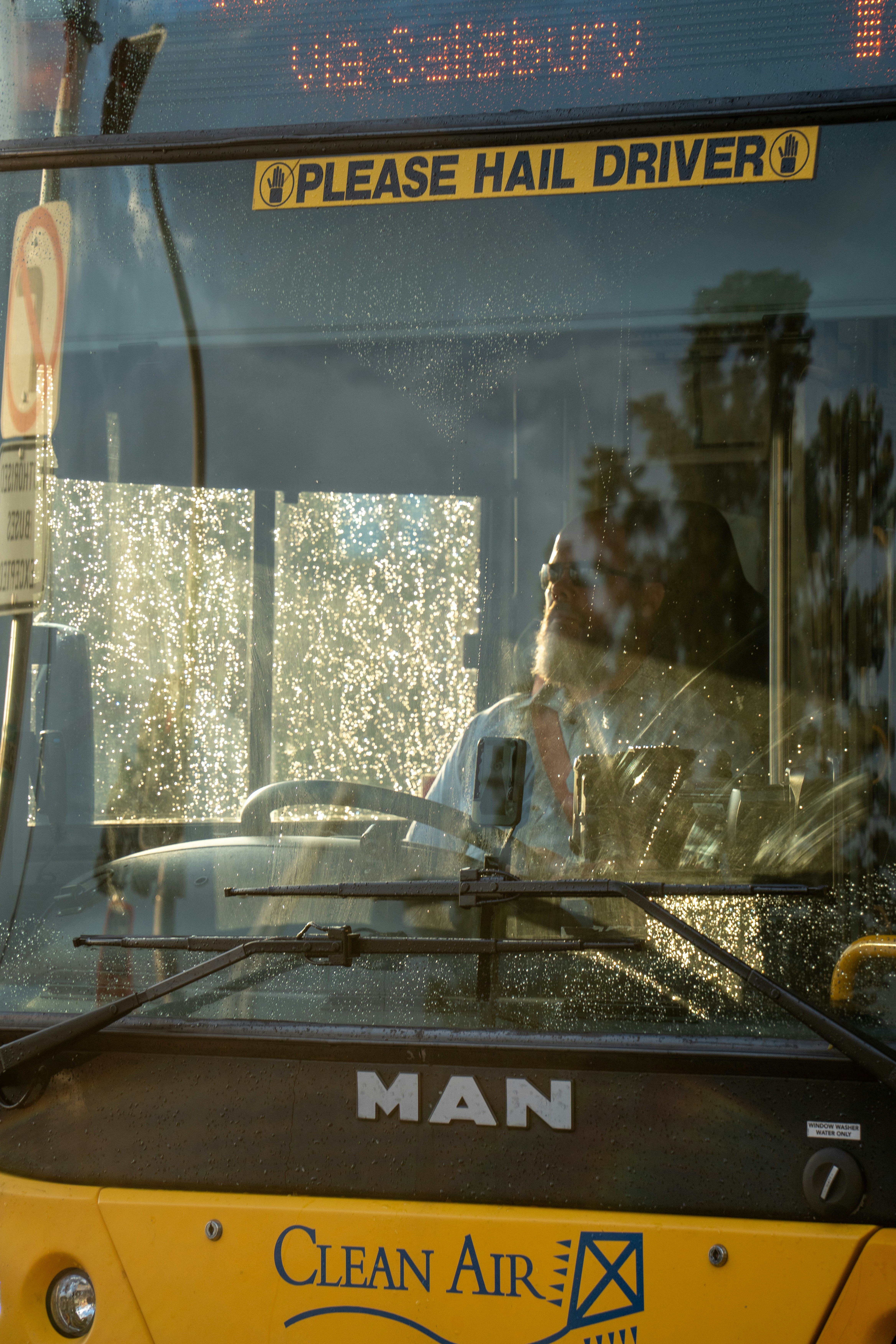 A driver in uniform politely assisting a passenger in a wheelchair.