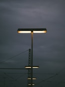 Streetlights illuminate a cloudy, dark sky.