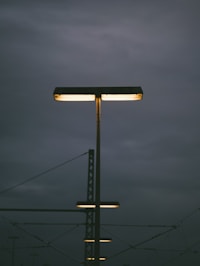 Streetlights illuminate a cloudy, dark sky.