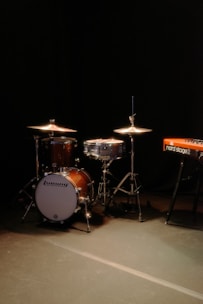 Drum set and keyboard on a dark stage