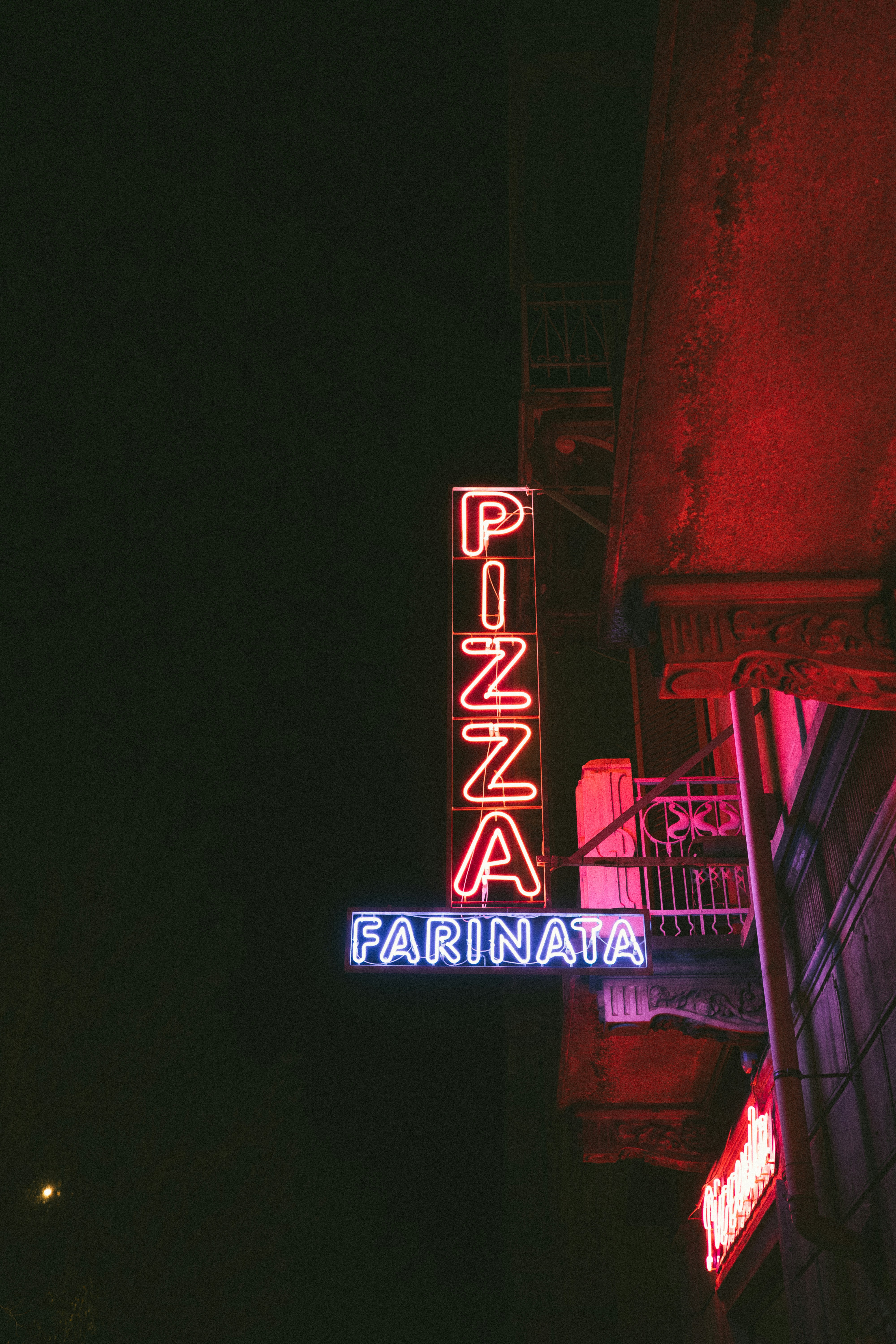 Neon pizza sign glowing at night
