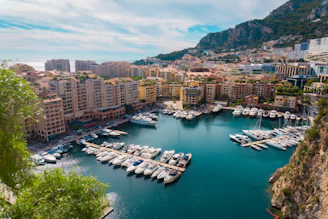 Boats docked in a mediterranean harbor with city buildings