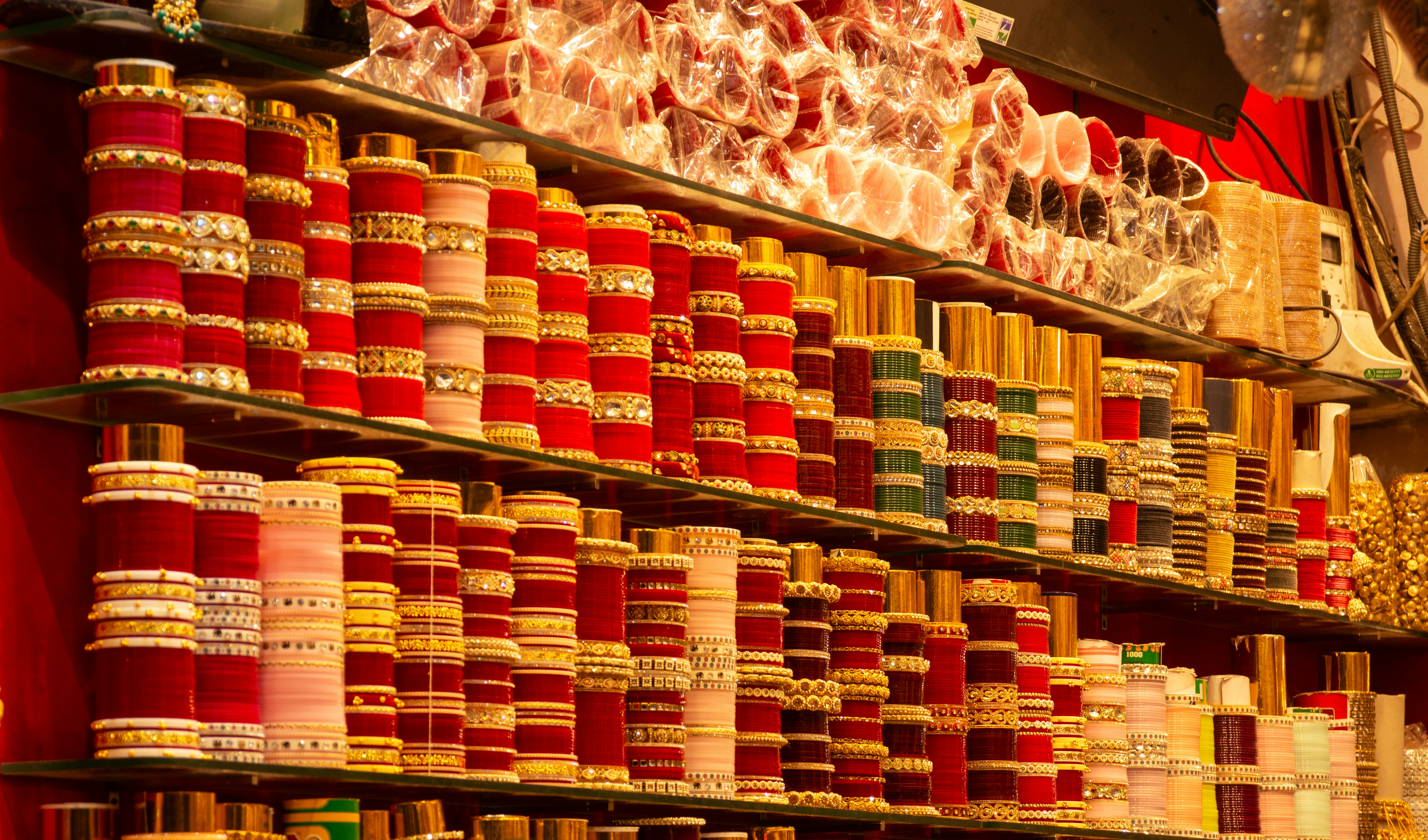 Rows of colorful bangles and bracelets displayed on shelves.