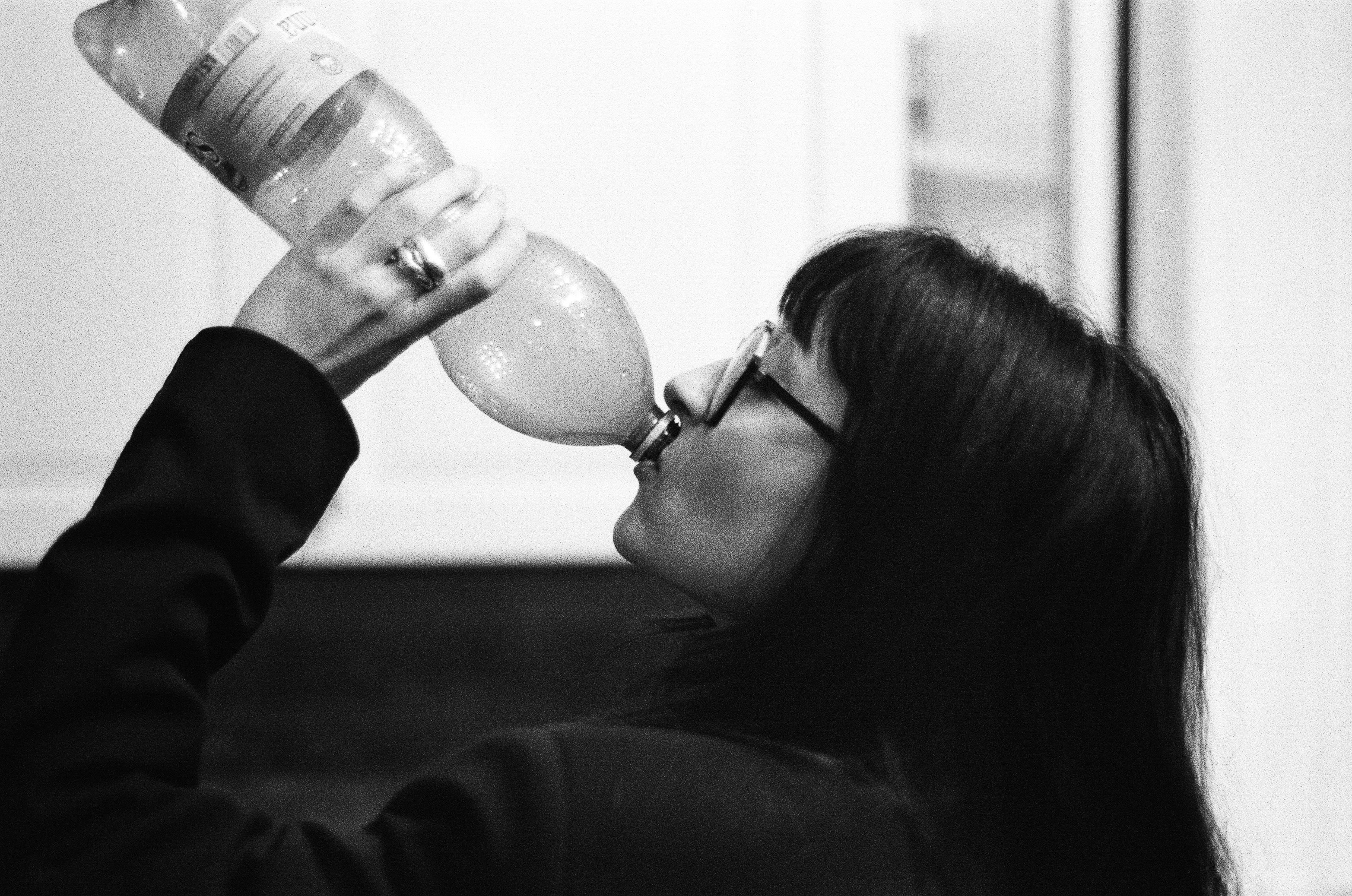 Woman drinking from a bottle with a balloon