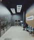 A person sits in a modern laundromat with machines.