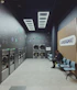 A person sits in a modern laundromat with machines.