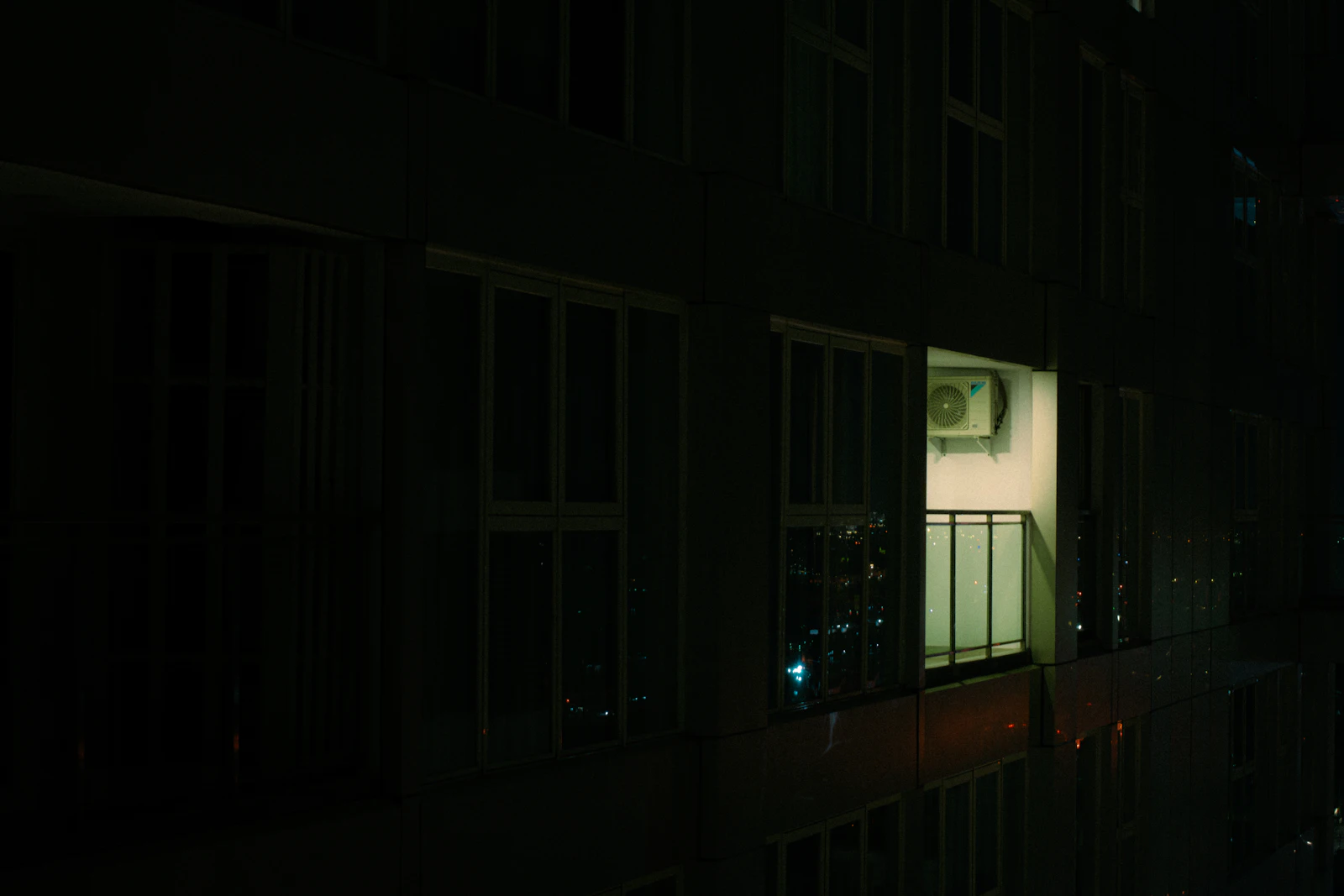 One brightly lit window in an otherwise dark apartment building at night, representing how rarely a retrieved page is actually the one ChatGPT opens and cites out of the many surfaced into its results