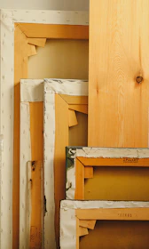 Stacked canvases and wooden boards in studio.