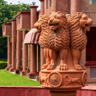 Four lions on a pillar with wheels and animals.