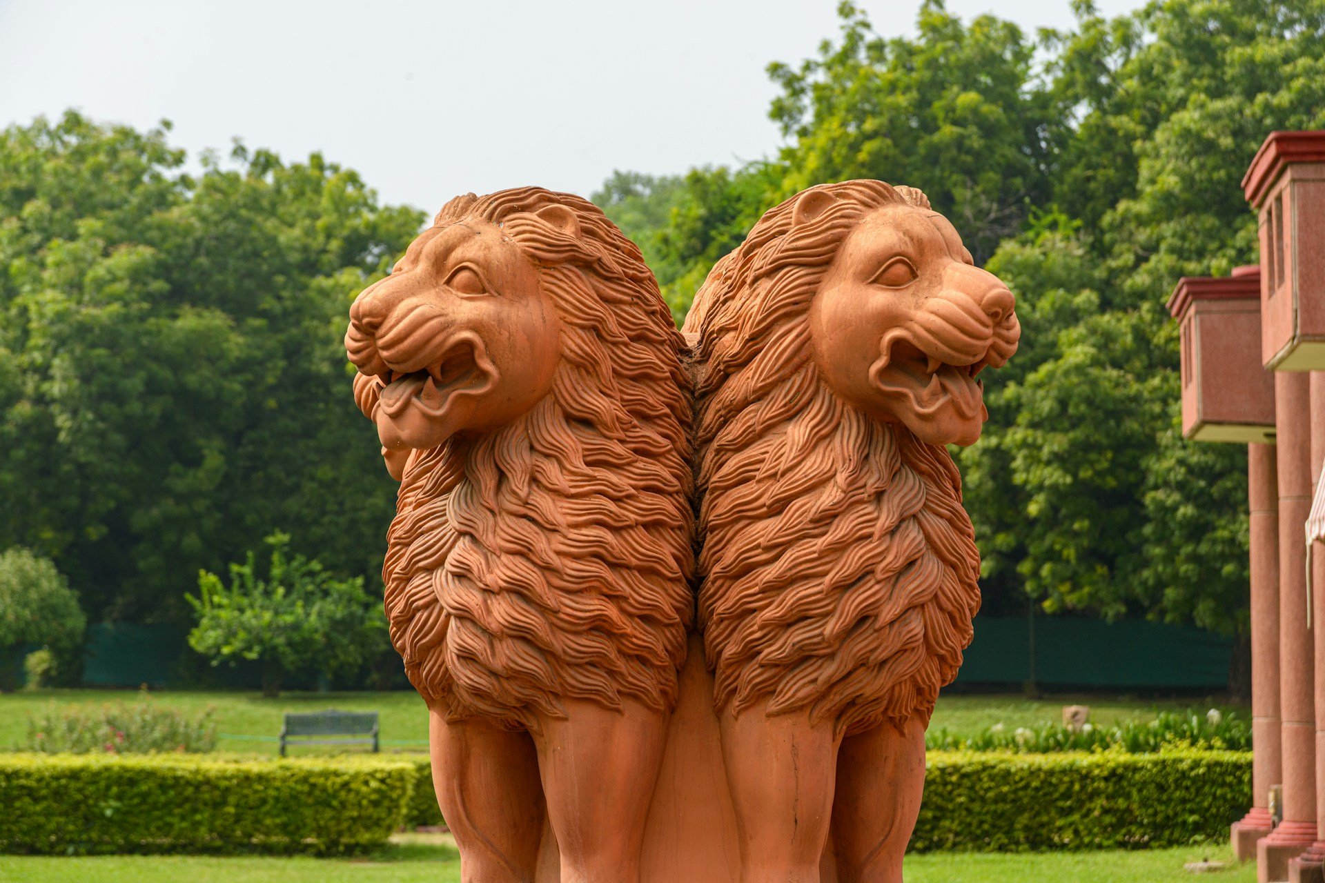 Two lion statues stand guard in a garden.