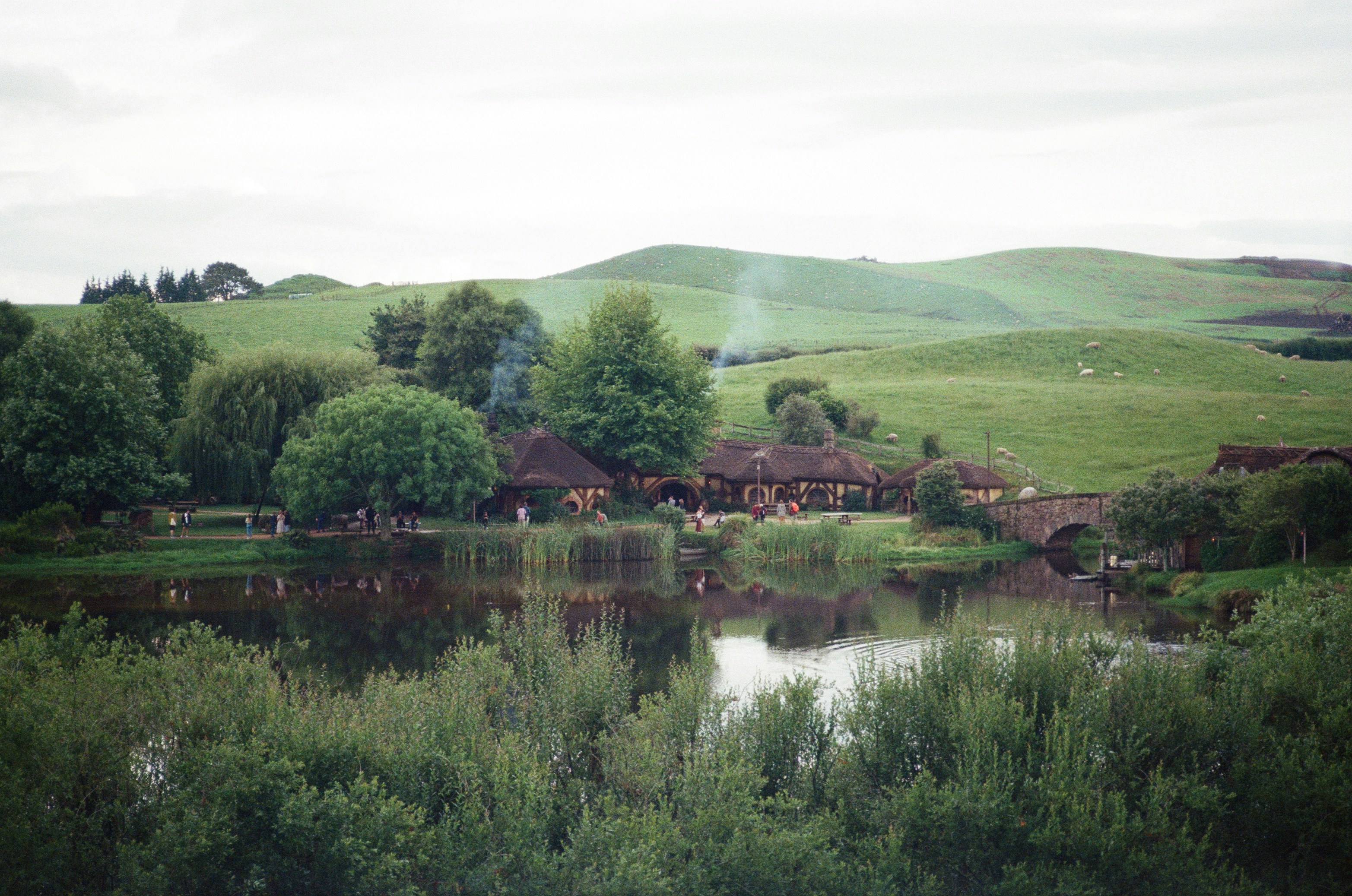 Case Hobbit immerse in un tranquillo lago con dolci colline.